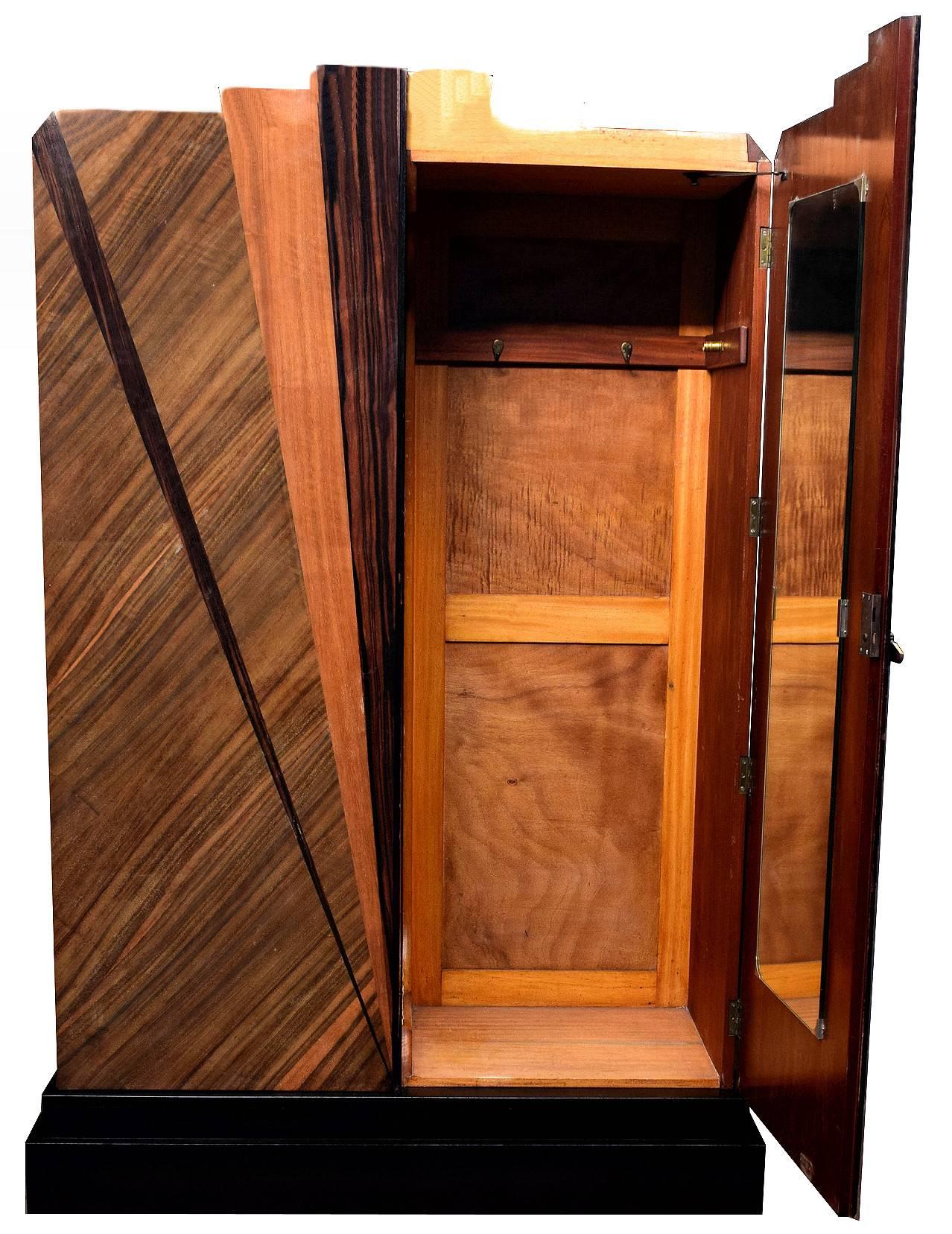 For your consideration is this wonderfully designed Art Deco wardrobe, totally authentic and originating from England. The main body is made from Mahogany and then various veneers make up the geometric patterned doors, all of which rests on an