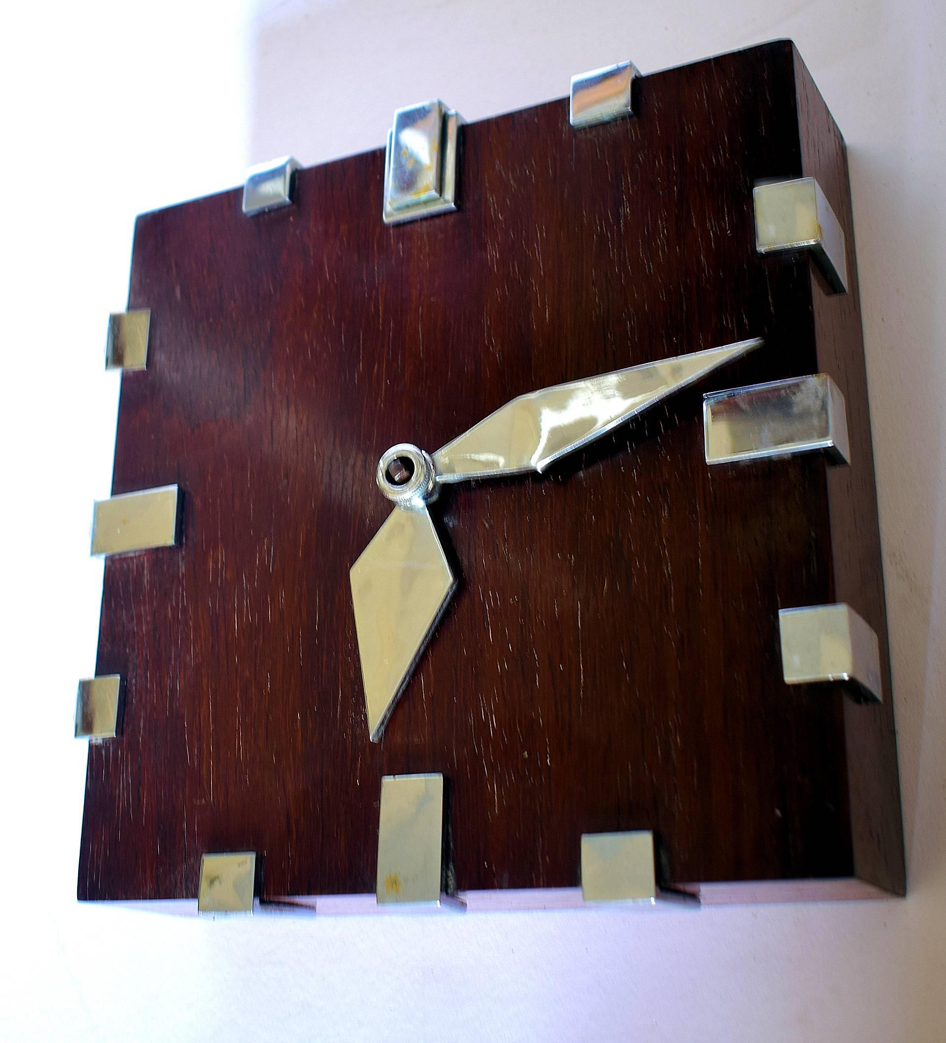Rare 1930s Art Deco Modernist wall clock by Zenith. The case is in Palissandre wood a beautiful colouring with the stylized numbers and hands in silver on solid brass in high relief. Marked to the back SWISS MADE 18 DAYS / 18 DAYS. Fully serviced