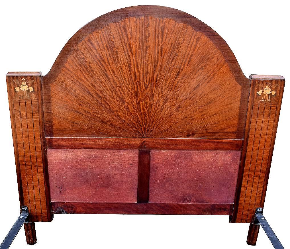 Beautiful Art Deco bed frame in walnut veneer with lighter wood detailing. Totally original and having been through our workshops has been fully and professionally restored. Features a huge half circle headboard with floral inlay either side as
