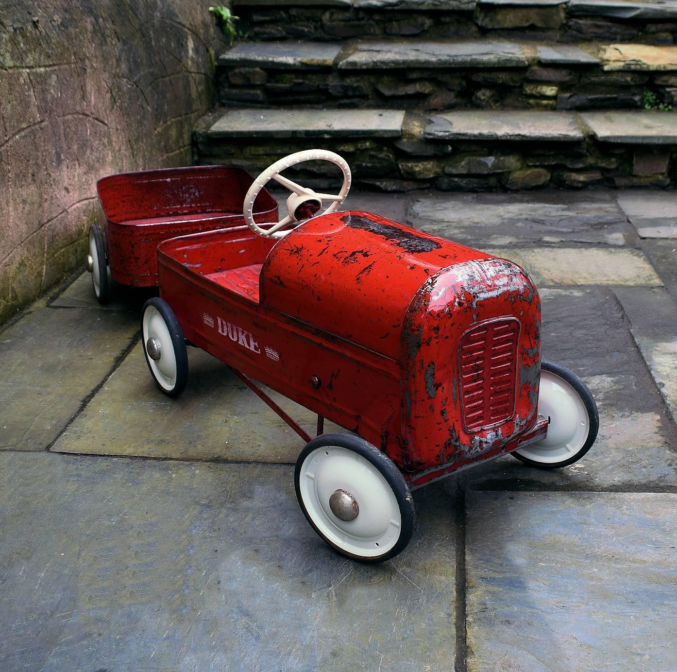 This is a wonderful opportunity to acquire Triang Duke pedal car, circa 1950 with a matching Triang Tri-Trailer, circa 1960. Totally authentic with original paint work and sign writing, right down to the chrome hub caps. Sympathetically restored and