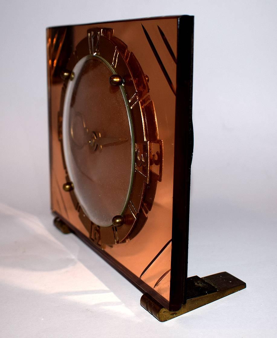 Art Deco English Mirror Glass clock dating to the 1930's. Lovely crisp and unblemished mirror dial in a peach colouring, looks very glamourous. Gold tone bezel and feet. Wind up movement which we've just had professionally serviced so comes to you