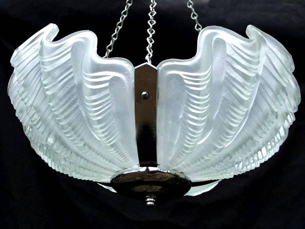 A large and heavy Art Deco ceiling light in lovely original condition. The chrome frame housing three large opaque shell type shades, these are held in place by chrome brackets which secure each petal individually and make them slot together firmly.