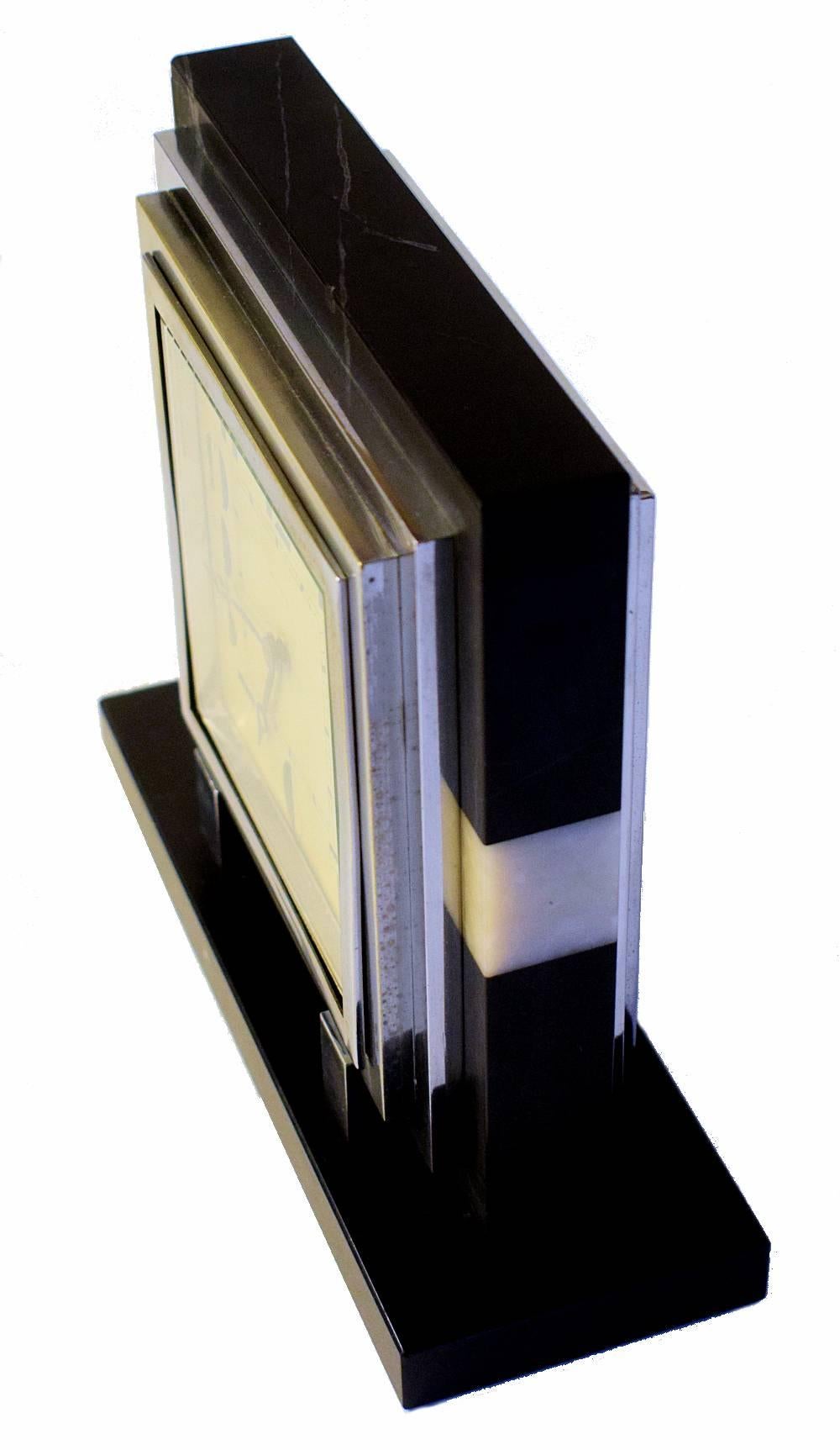 Stylish 1930s Art Deco French 8 day marble mantle clock. The ultra stylised deco numerals absolutely make this clock and ensures it can't be mistaken from any other era or style. The casing is a mix of solid marble and slate. The chrome bezel shows