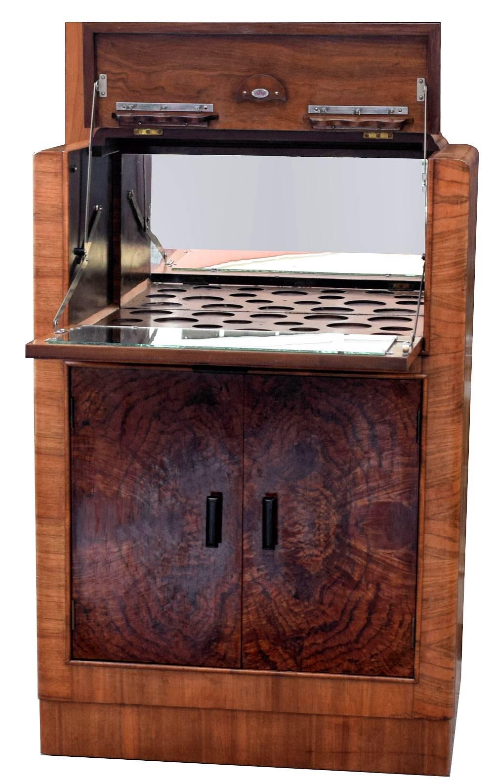For your consideration is this stylish English Art Deco, 1930s figured walnut cocktail cabinet. This is a great looking period piece with exceptionally attractive walnut veneers. The drop down section at the top reveals a full mirrored interior with