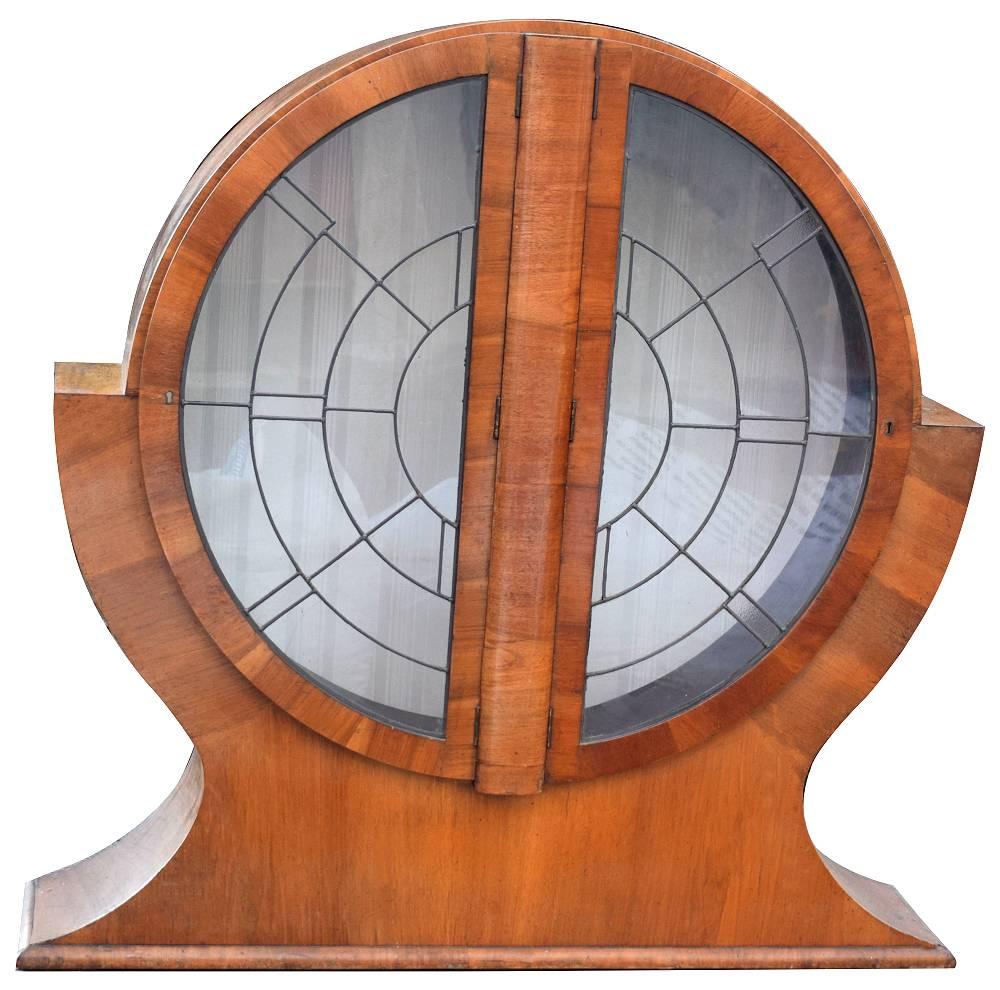 This is a superb 1930's Art Deco cabinet. This walnut cabinet is what we've chosen to call a "Keyhole" shape and it originates from England. Veneered in mid-tone walnut and features a generously sized interior display area for your wares
