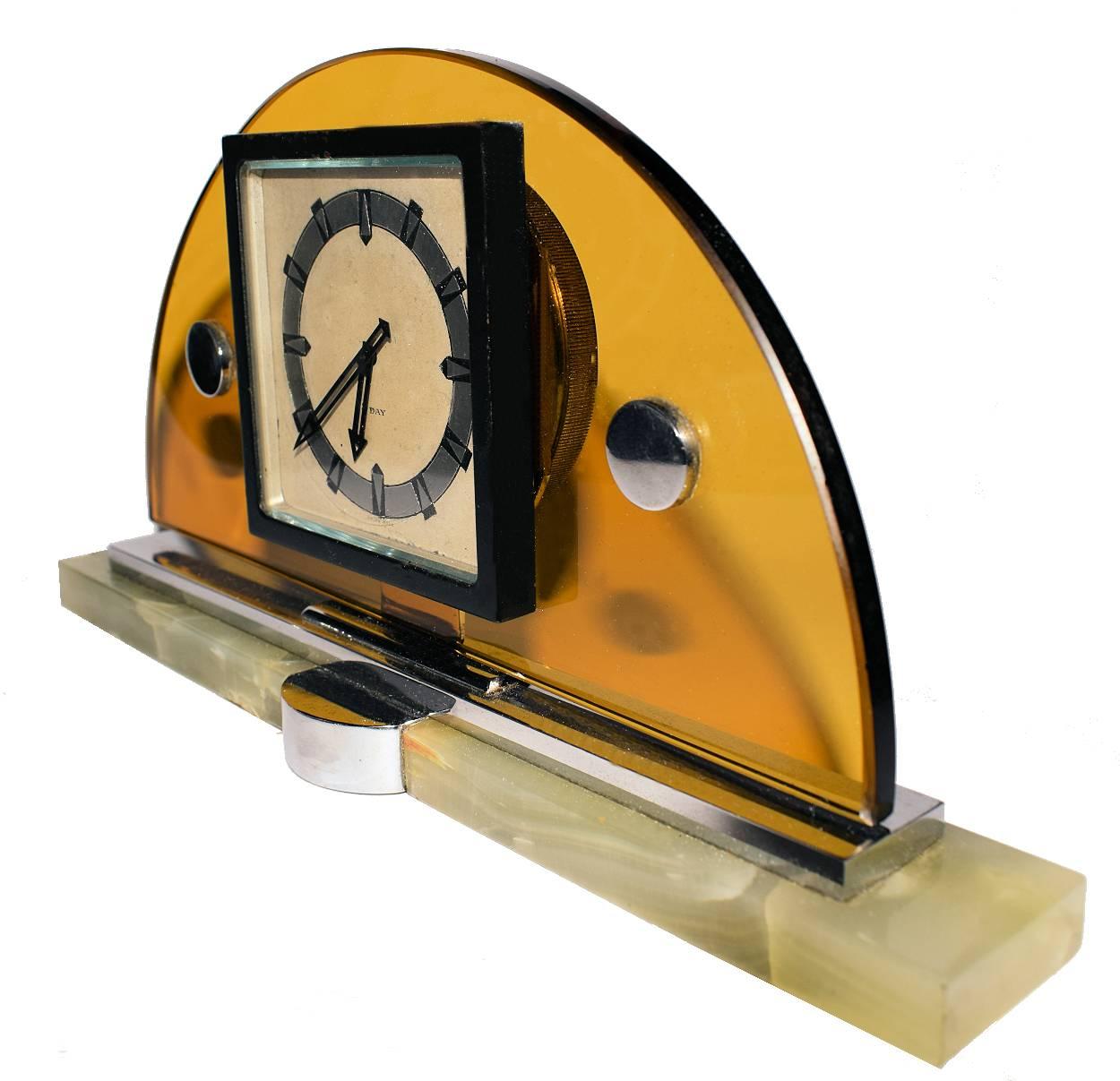 Pour votre considération, voici un bel exemple d'une horloge de cheminée moderniste Art Déco Suisse 8 jours - Swiss Made. Il présente un épais croissant de verre jaune qui repose sur une base en chrome et en onyx. Le cadran de l'horloge affiche des