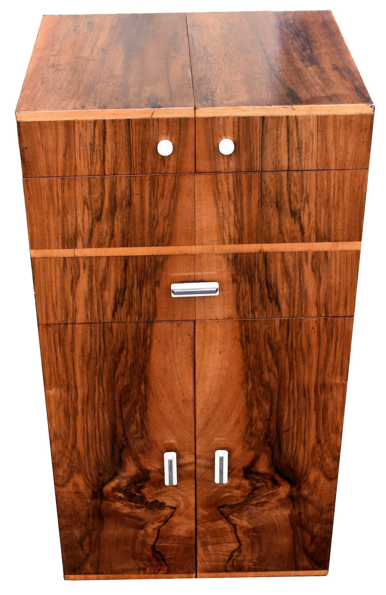 This is a rare and wonderful opportunity to purchase a high end portable cocktail dry bar dating to the 1930's. A classy Art Deco figured walnut cabinet with highly figured veneers on all sides including the back and in excellent condition having