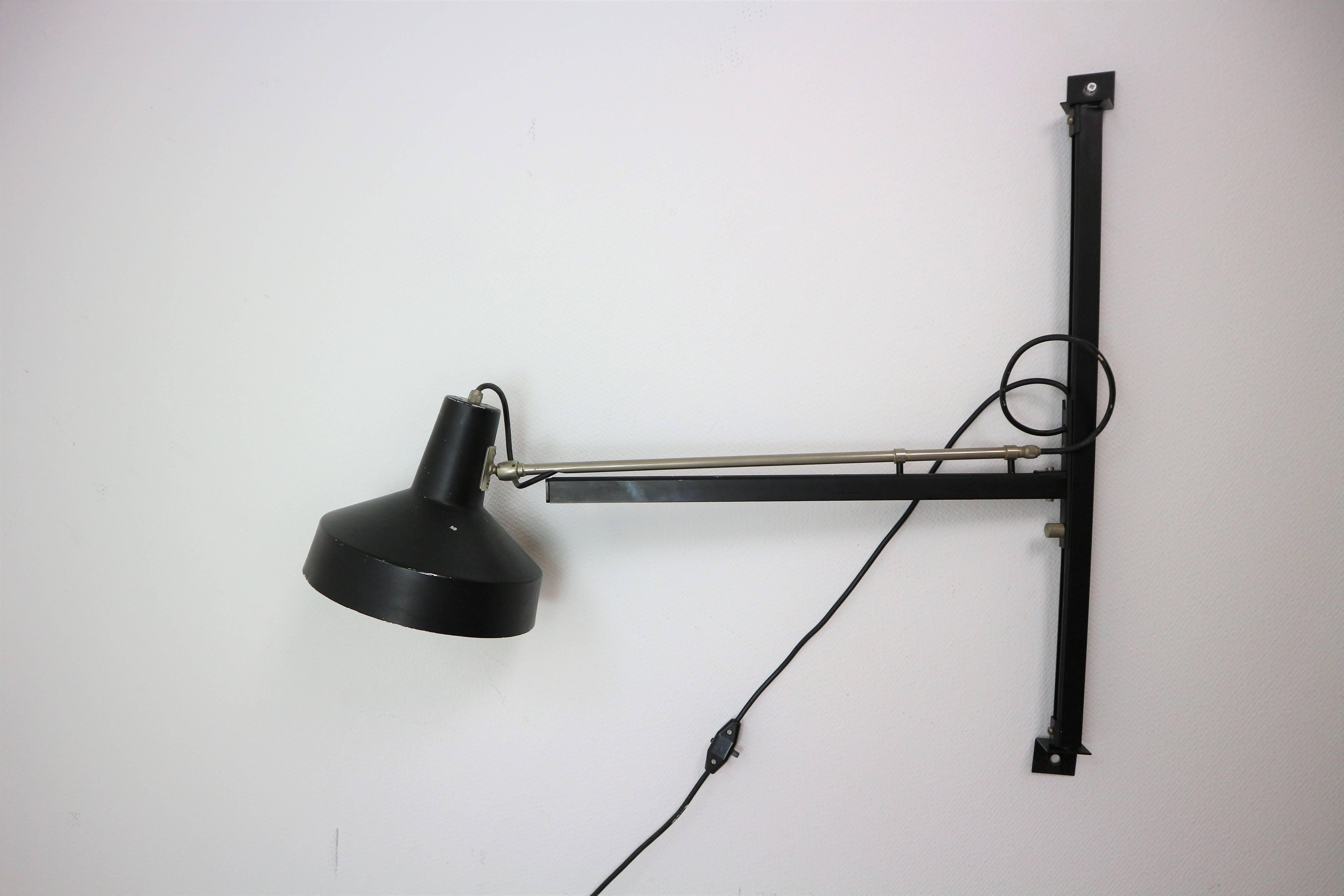 Telescope wall lamp designed by Niek Hiemstra, circa 1960 for Hiemstra Evolux. The lamp is adjustable in height along the wall suspension and the arm can be extended by pulling it and can rotate 180 degrees. The shade can be directed in many