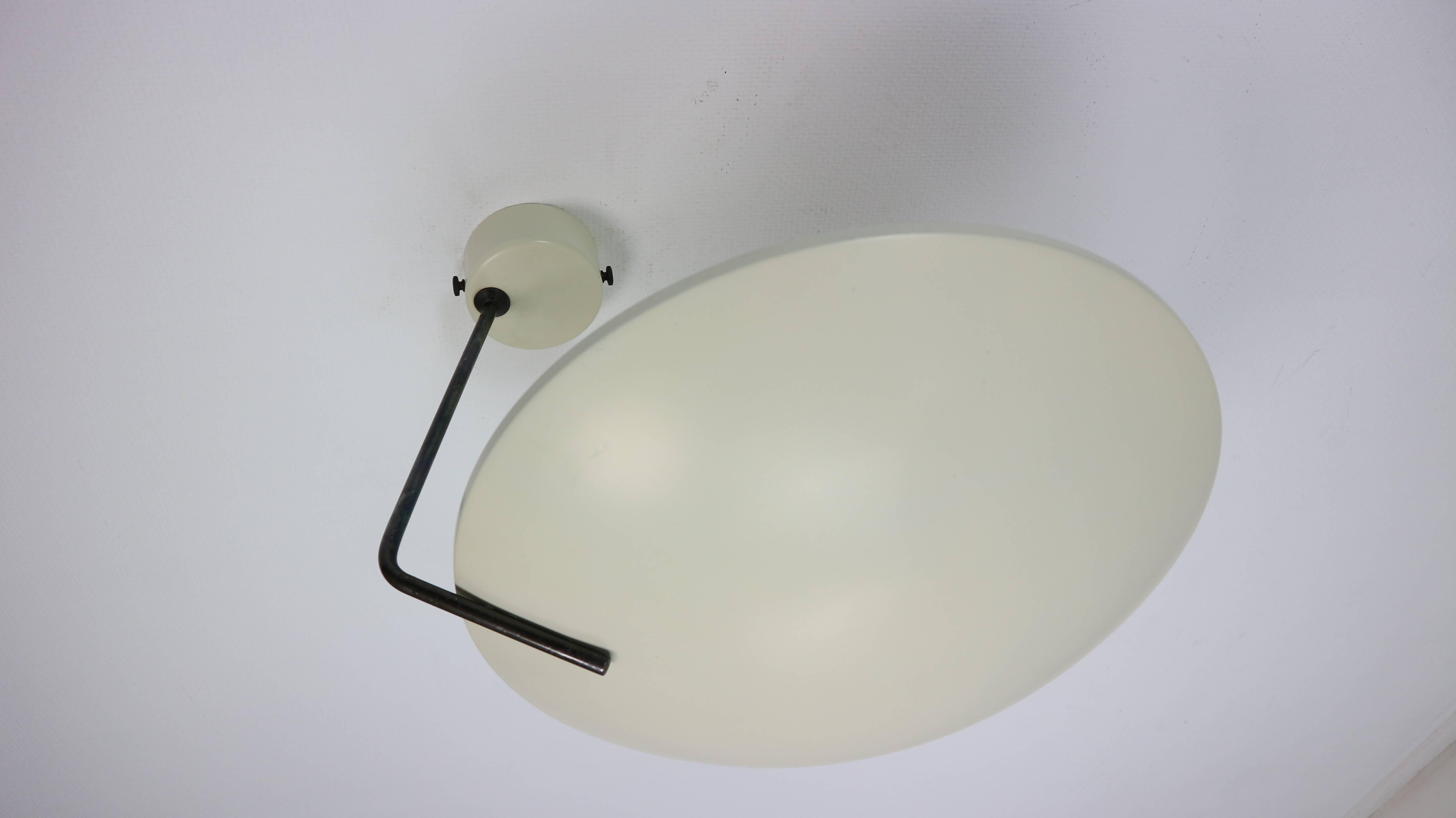 This wall or ceiling lamp model 232 was designed by Bruno Gatta for Stilnovo Italy in 1962. This lamp has a white lacquered shade and black ebonized arm, white wall plate as well attached to the wall with black ebonized screws. This lamp is in