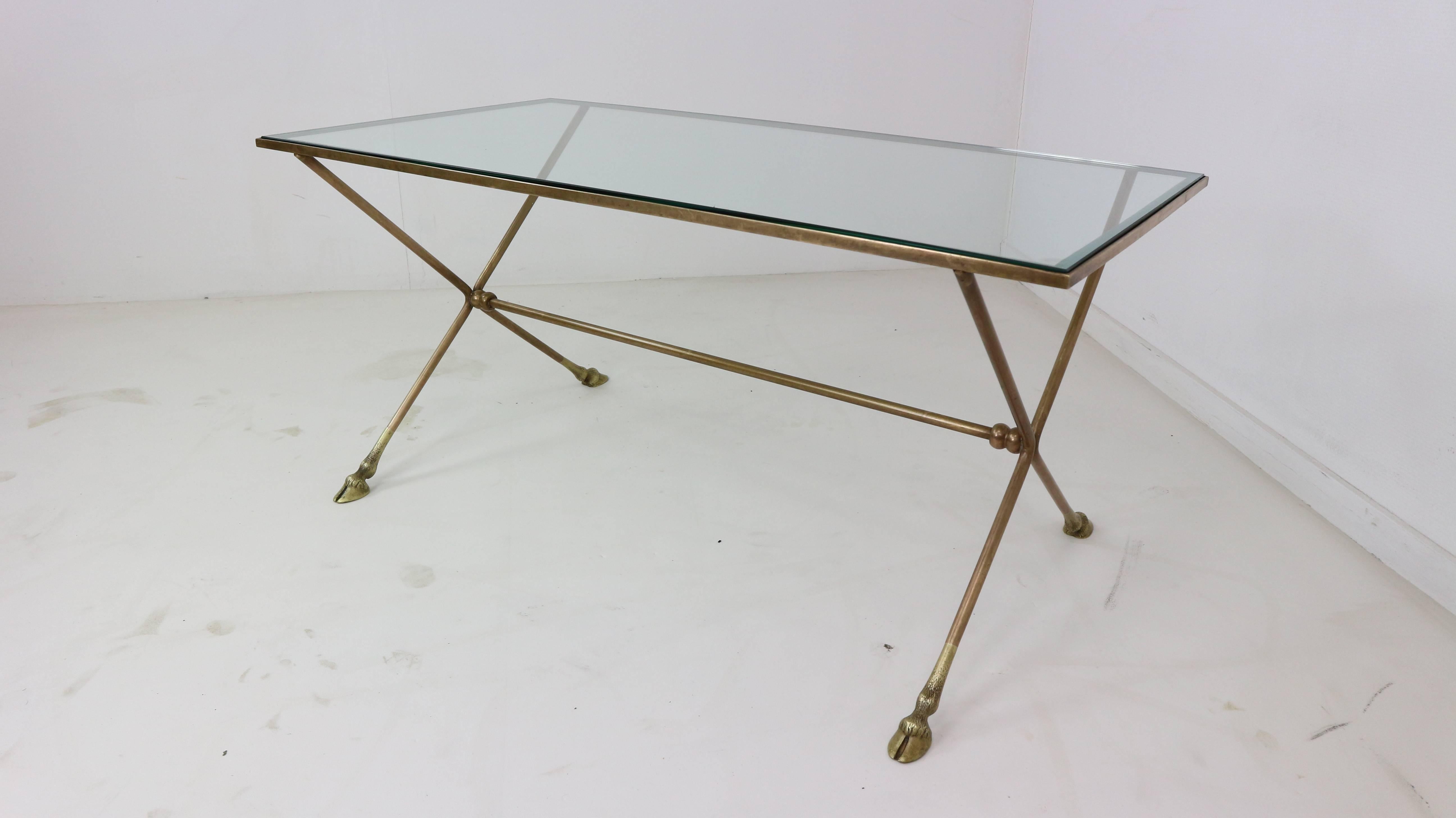 Chic Maison Jansen Directoire style bronze/brass cocktail table with hoof feet and glass top, France, circa 1950.

 