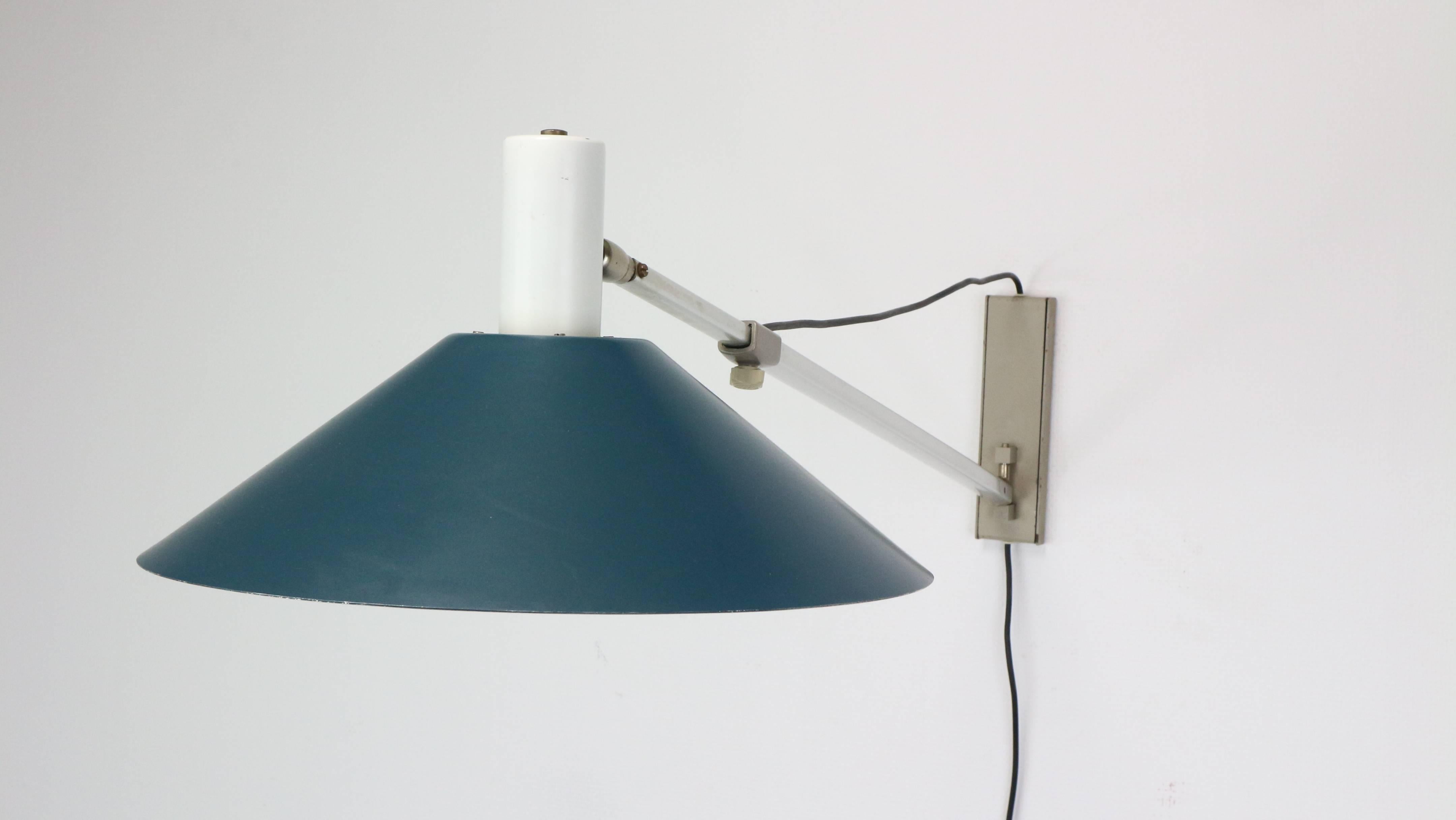 Fantastic adjustable wall lamp model 7093 designed by J.J.M Hoogervorst for Anvia Almelo, Holland, 1957. This lamp has an aluminium anodized arm and blue lacquered shades and grey wall plates. The lamp is adjustable in length hand can rotate in many