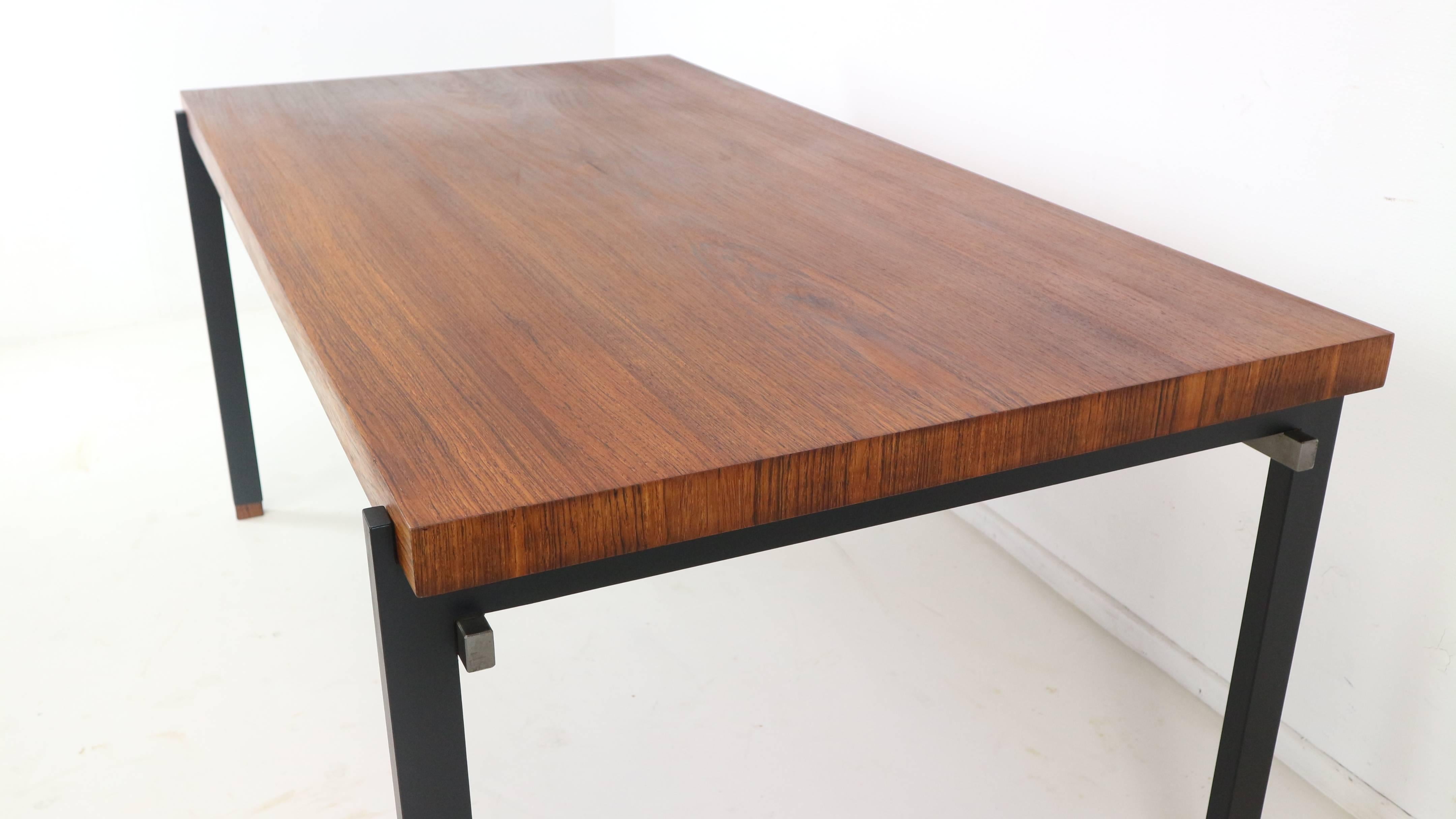 This dining table by Alfred Hendrickx, was designed in the 1960s for Belgian company Belform. The table features a rosewood veneered top and a modernist black metal and nickel colored frame with rosewood socks.