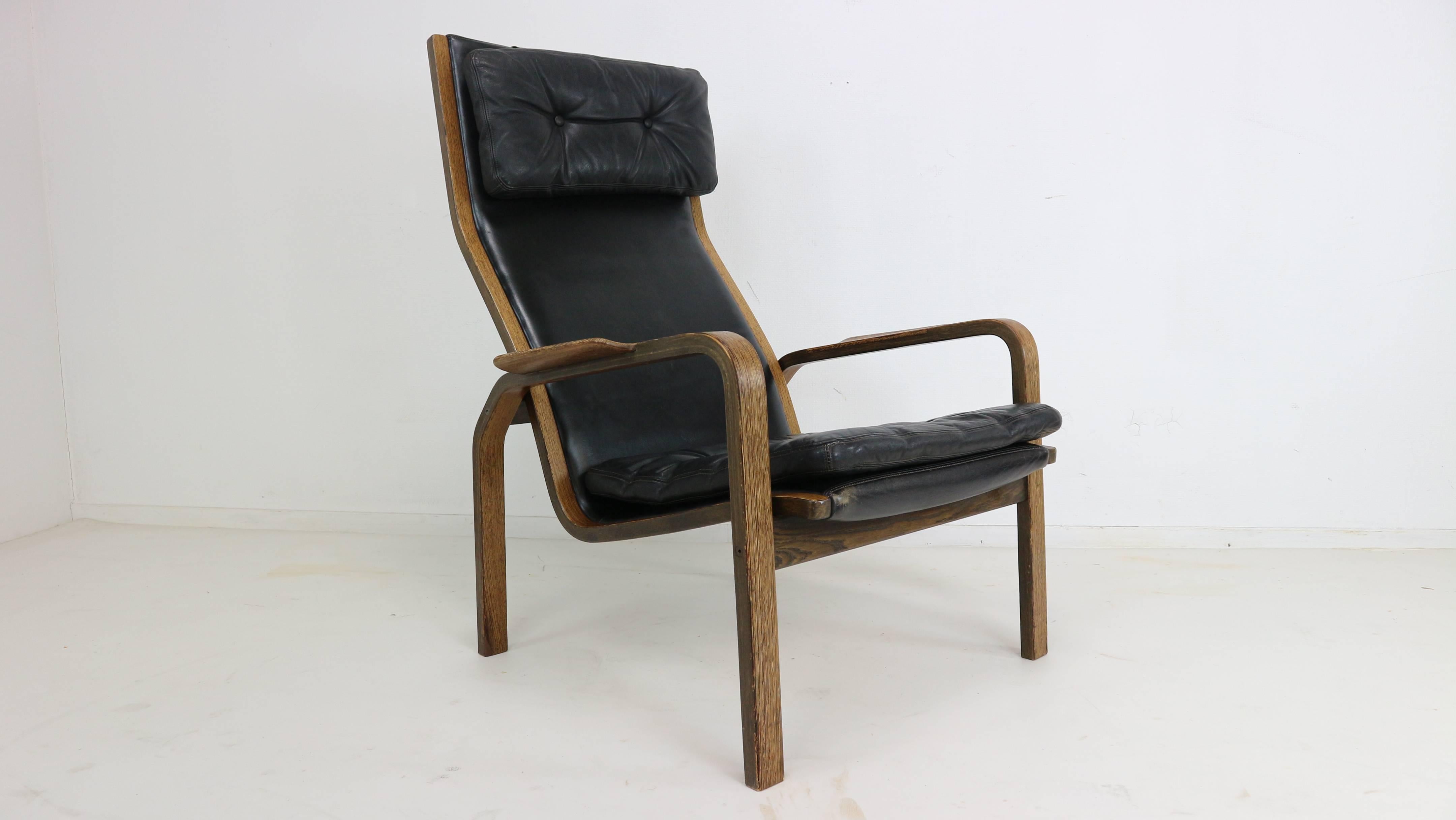 Pair of Scandinavian (Swedish) armchairs manufactured in the 1960s and designed by Yngve Ekstrom. Structure in plywood wengé and black leather. Some marks of wear on the feet. The chairs are marked by the maker.
