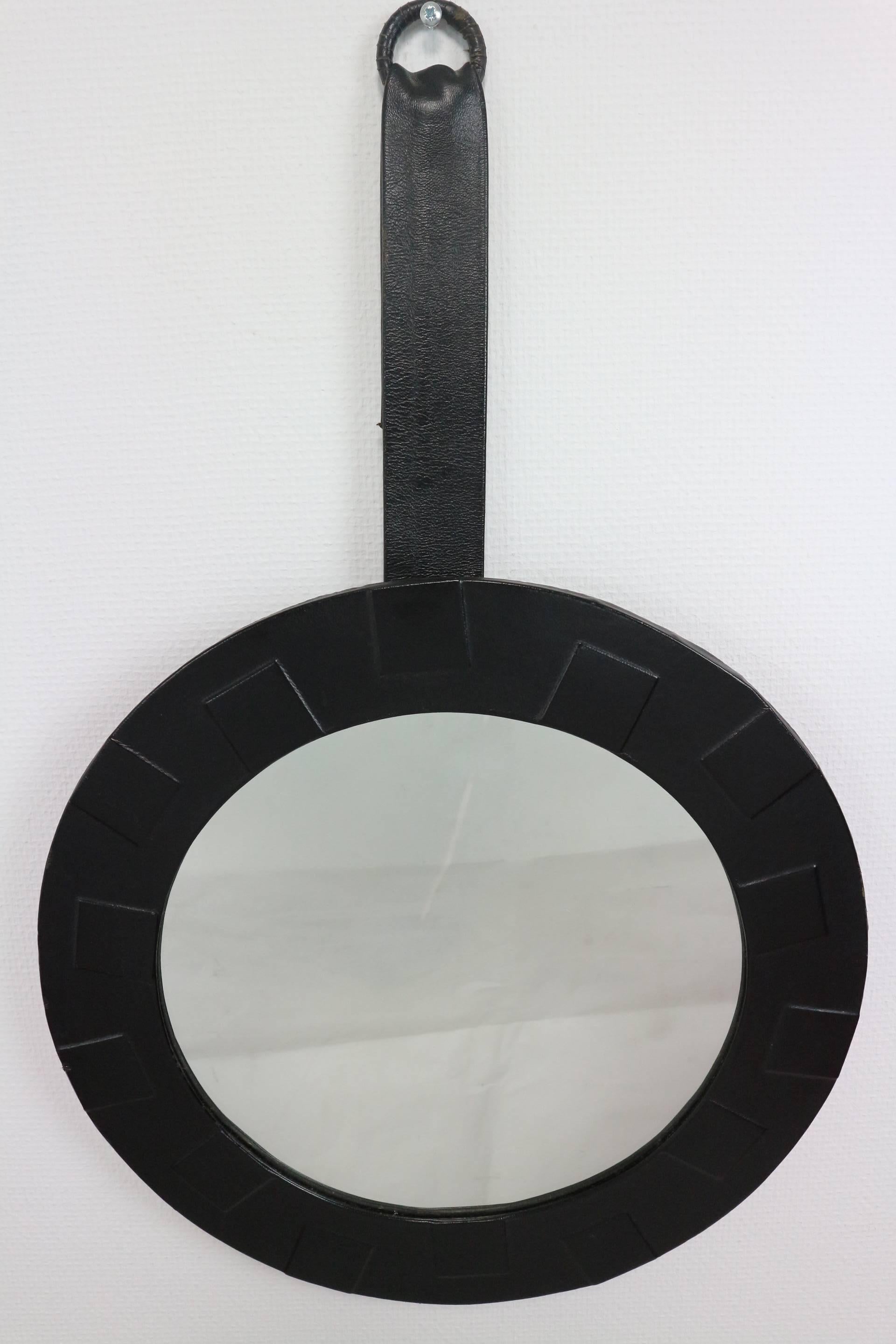 Unique design, round mirror framed in black leather and leather covered hang-system. 

We ship worldwide, do not hesitate to contact us. We inform you about the best price available, customized to your order. We make sure your purchased item is