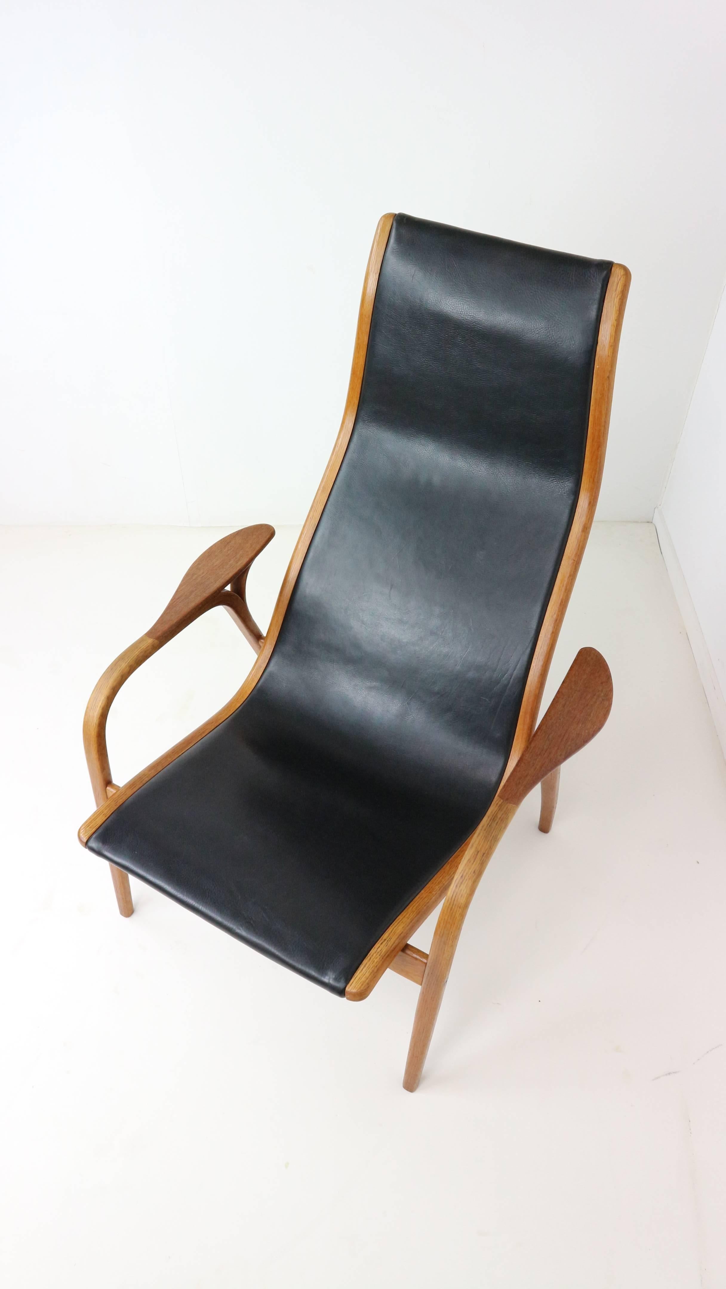 This vintage Lamino chair was made in Sweden by Swedese and designed in 1956 by Swedese founder Yngve Ekstrom. The bentwood chair frame is teak wood with the original black leather, which has minimal wear. The maker's mark is on the back of the