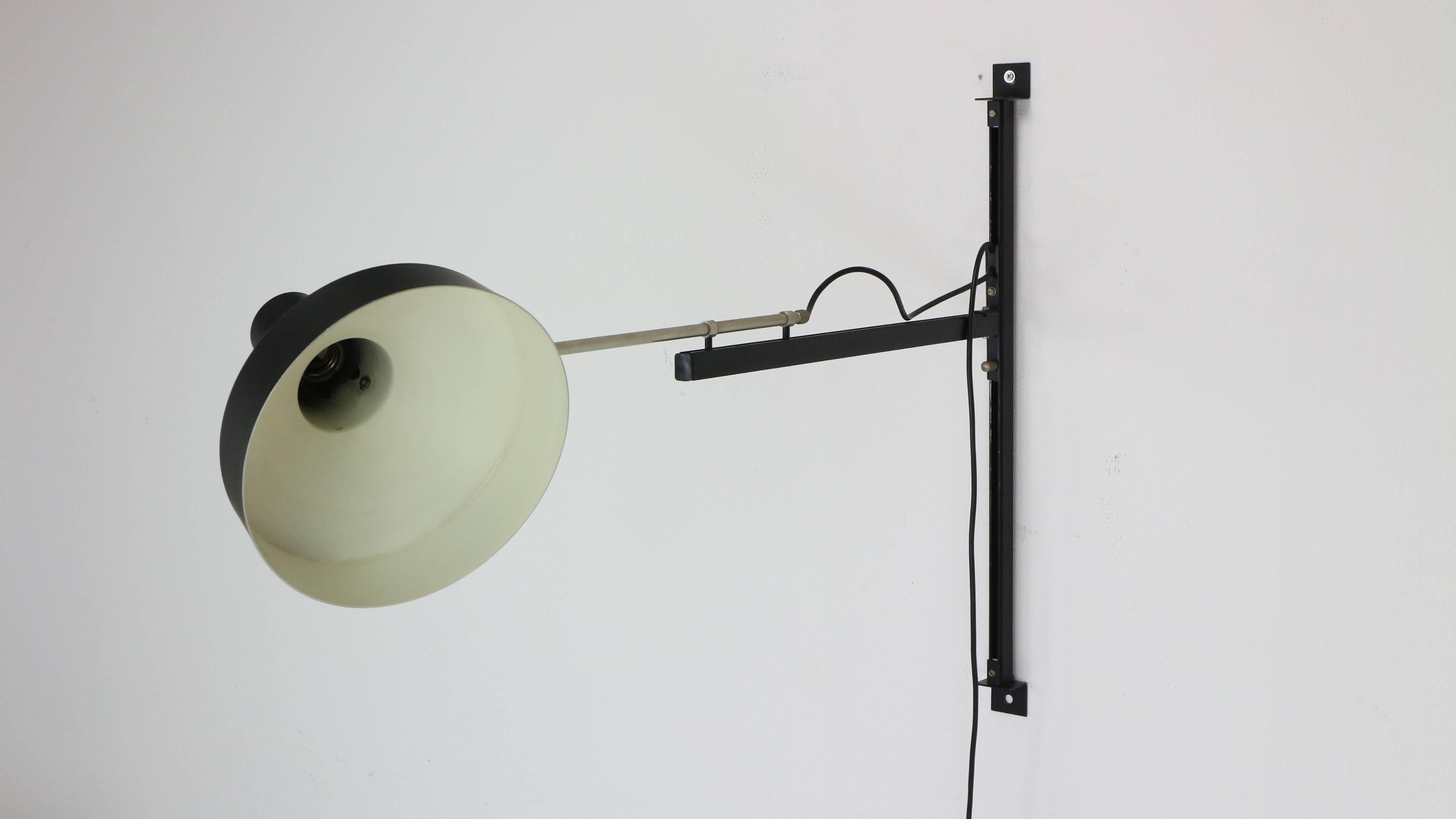 Telescope wall lamp designed by Niek Hiemstra, circa 1960 for Hiemstra Evolux. The lamp is adjustable in height along the wall suspension and the arm can be extended by pulling it and can rotate 180 degrees. The shade can be directed in many