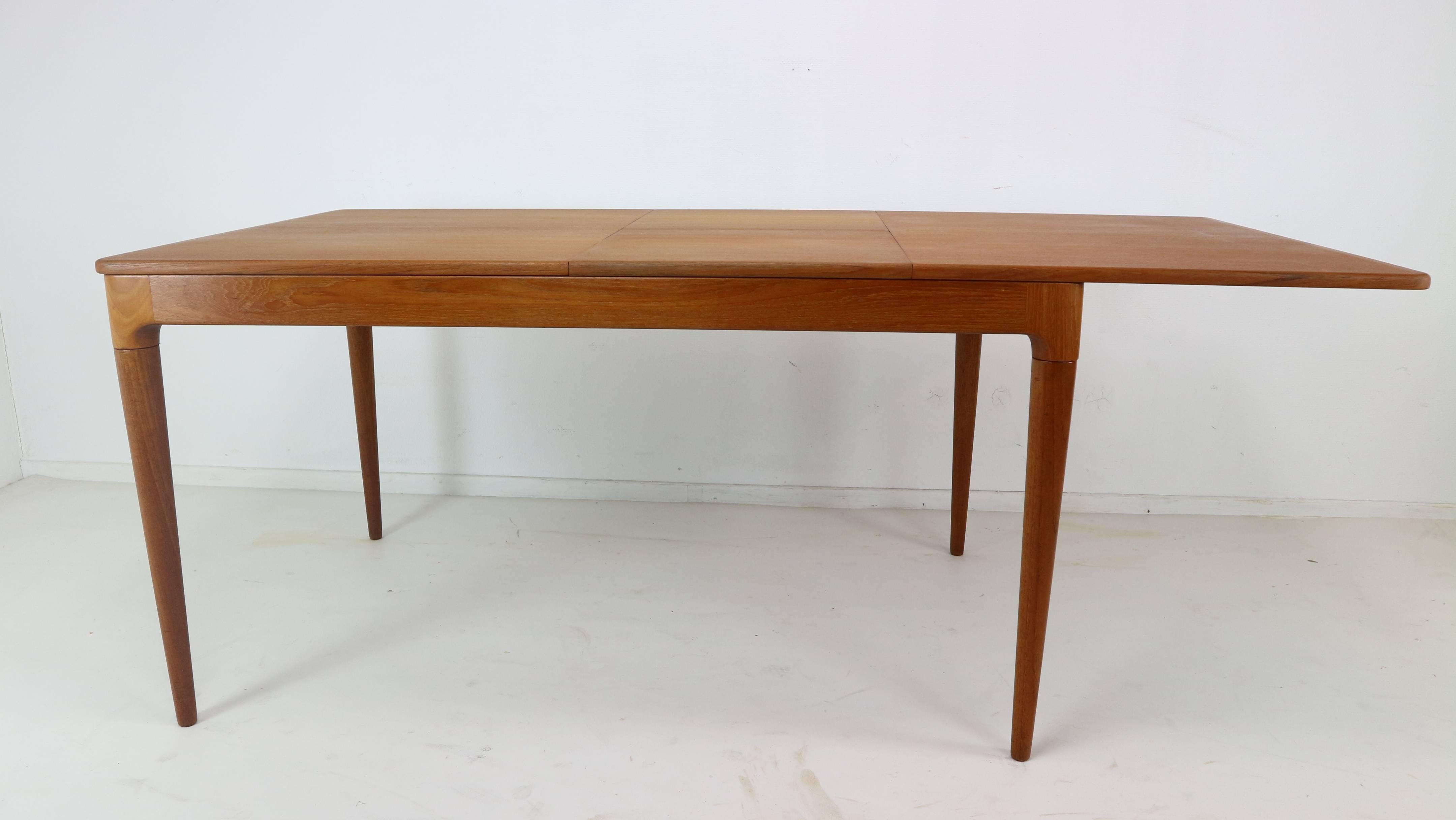 This Arne Hovmand-Olsen designed dining table epitomizes Danish craftsmanship at its finest. It is beautifully constructed with luxurious teak grain and vibrant color. The legs are substantial and supportive enough to accommodate two additional
