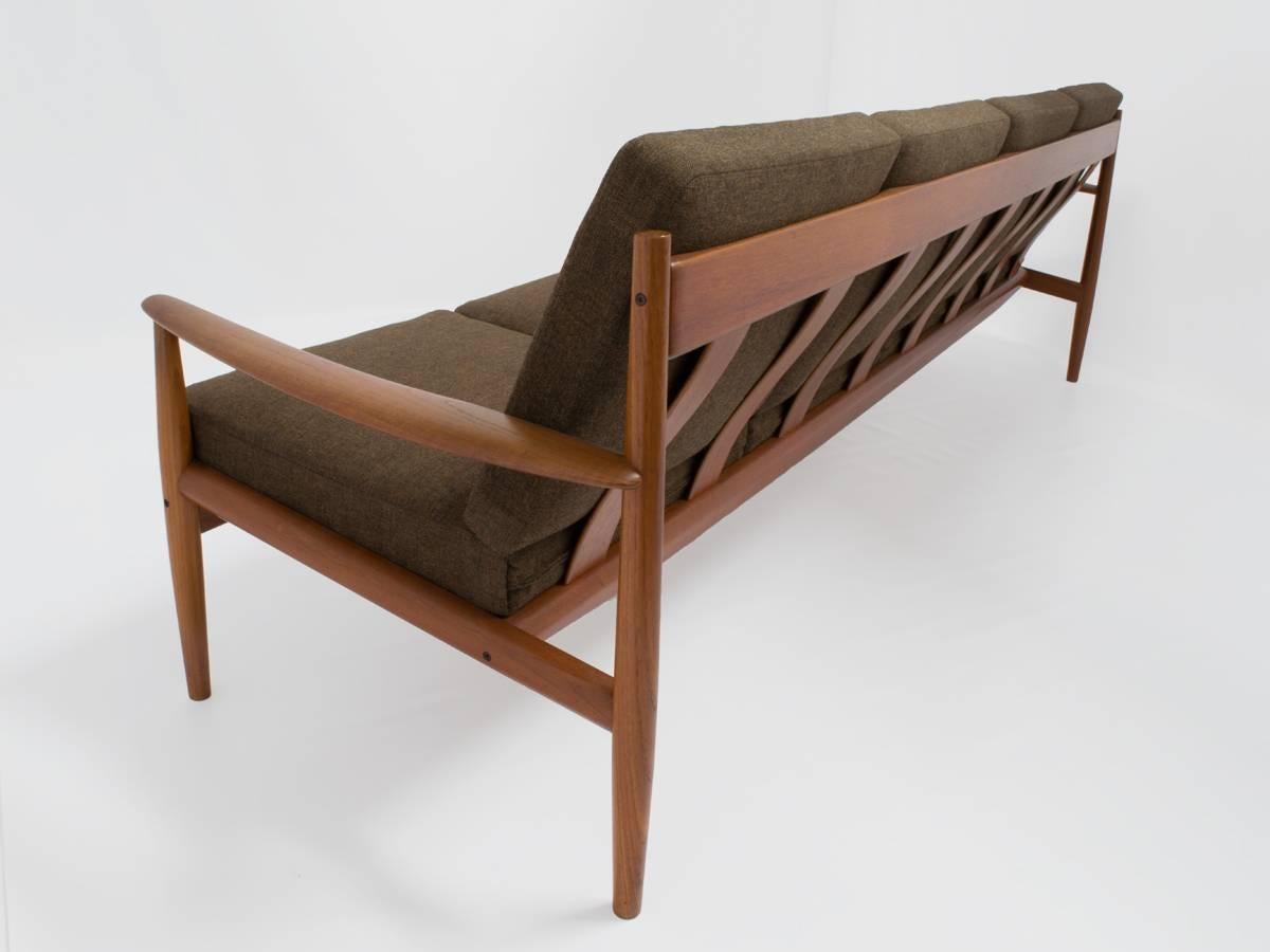 This mid-century sofa was designed by Grete Jalk and crafted by France & Son (model 118/4) in Denmark. Grete Jalk is considered one of the foremost designers of the Mid-Century Danish modern era. Beautifully long and sleek, it features a solid