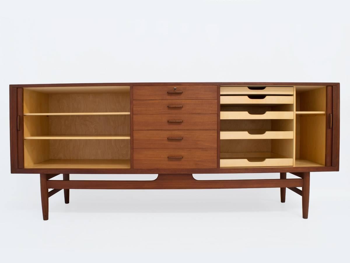 This mid-century Danish credenza or storage cabinet or sideboard is an exquisite example of authentic Danish cabinetmaker craftsmanship. This piece is attributed to architect Erik Worts for Henrik Wørts Møbelsnedkeri cabinetmakers and marked 
