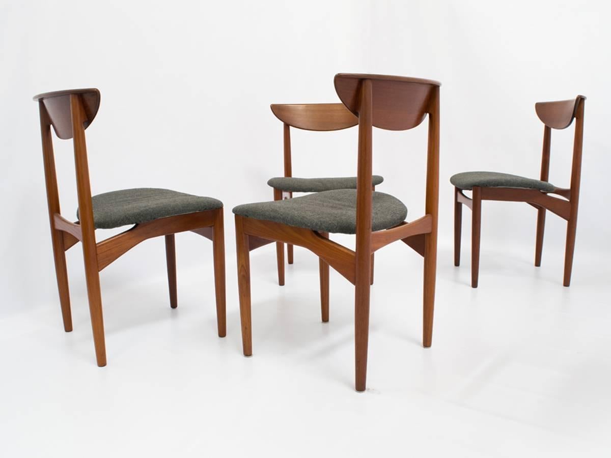 This elegant set of eight Mid-Century dining chairs in solid teak includes four armchairs and four side chairs. Designed by Kurt Ostervig and crafted by K.P. Mobler in Denmark, the chairs feature modernist architectural lines and beautifully