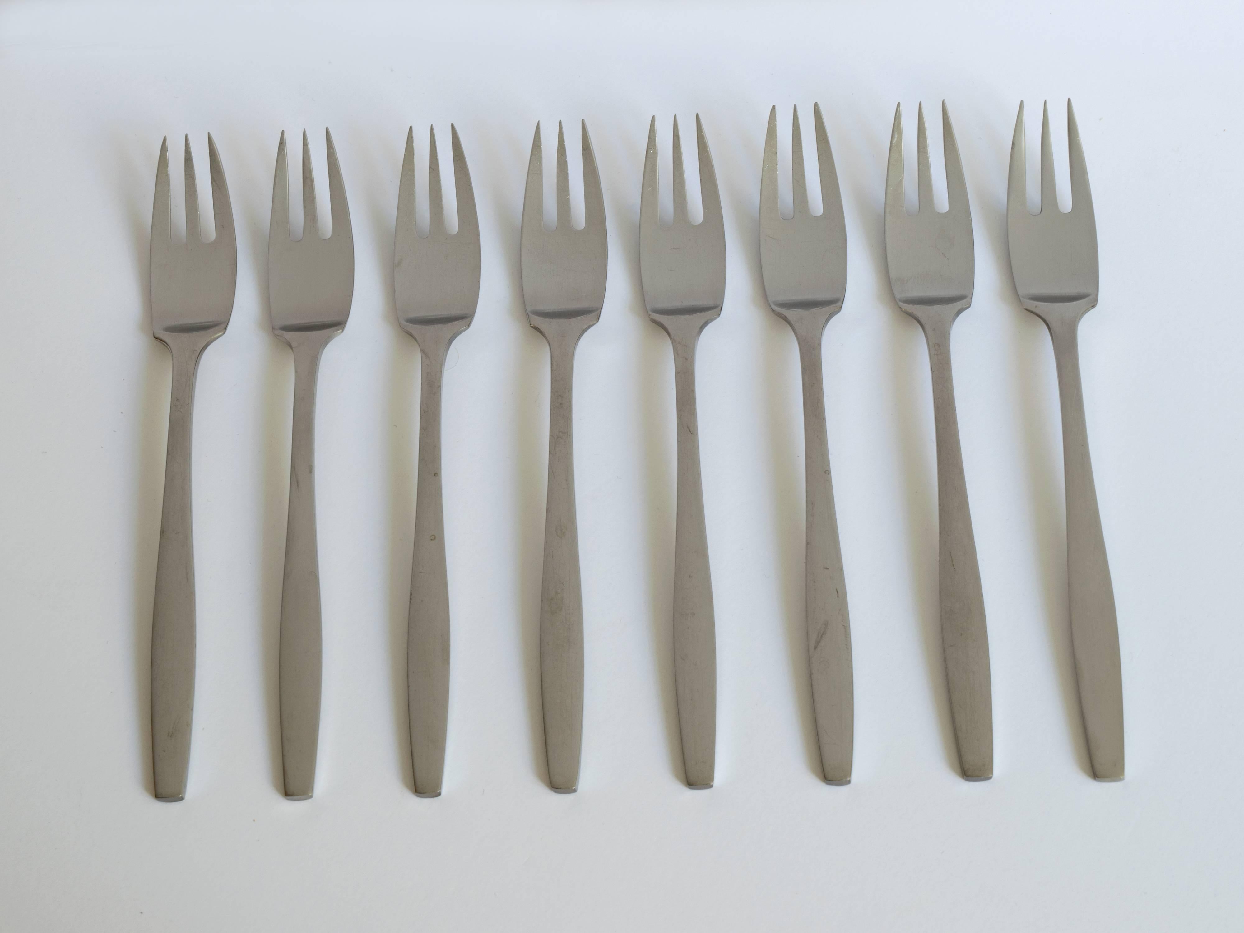 This elegant and minimalist stainless steel flatware, the "Variation V" pattern, was designed by Jens Quistgaard for Dansk Finland (note: the eight cocktail or seafood forks are by Dansk Denmark). The matte finish and modernist design is