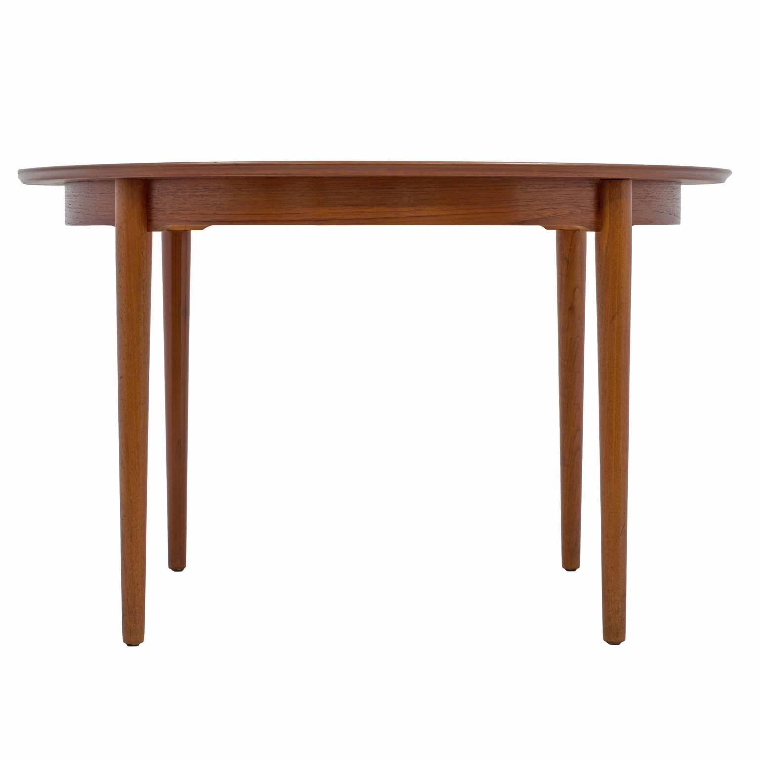 Gorgeous Danish modern dining table designed by Arne Vodder, in teak with two leaves. Without its leaves, this Mid-Century table is approximately 48” round; with one leaf, it measures approximately 67”; with both leaves, the table lengthens to an