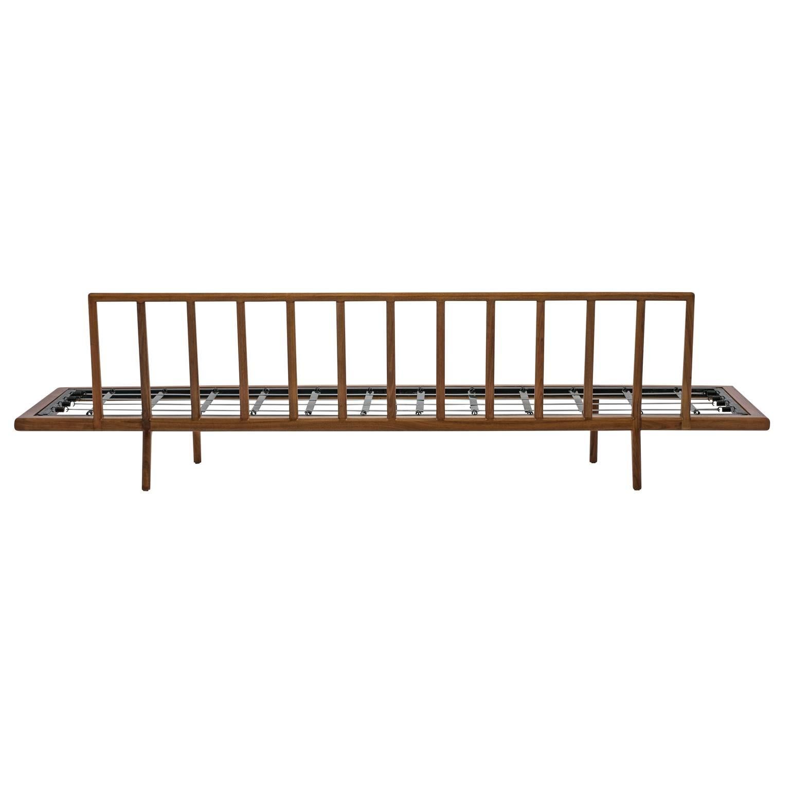 Long, low and sleek Mid-Century daybed or sofa frame by Mel Smilow for Smilow-Thielle. Finely crafted, this walnut daybed frame features a modernist rail back with a sprung-metal slat seat support. It has been refinished and is ready for your choice