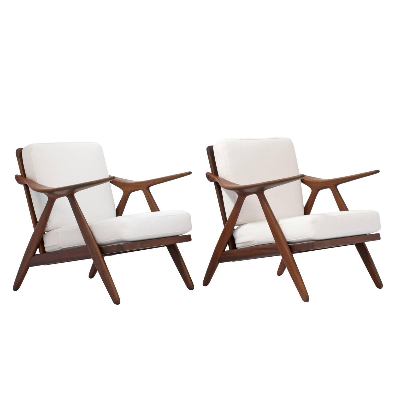 Pair of beautiful Mid-Century Danish lounge chairs by Arne Hovmand-Olsen, model 27, for Randers Mobelfabrik. The chairs feature fluidly formed arms and arrow slat backs. The frames are sturdy and strong in their original “as found” condition with