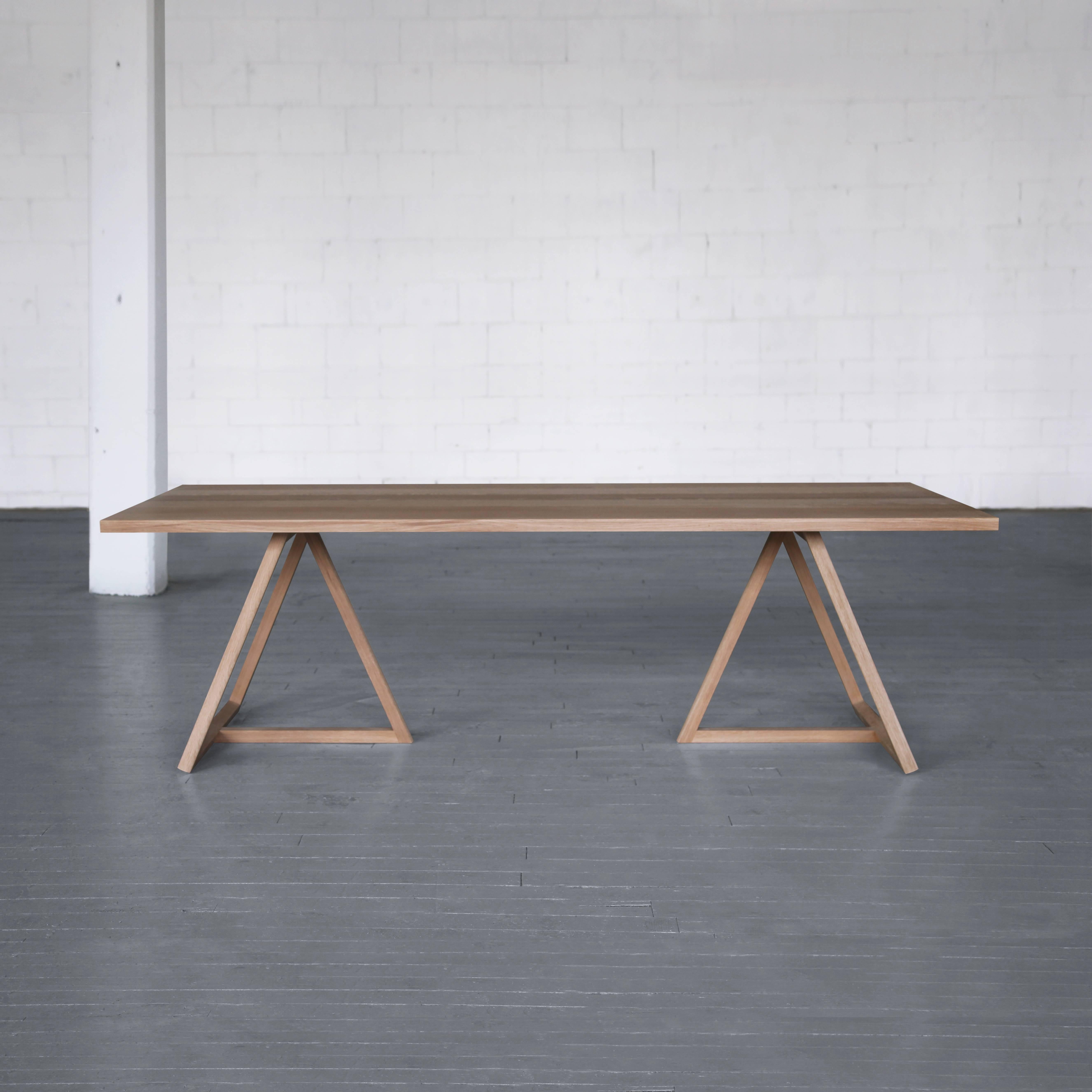 Shown here in white oak, the Thales tabletop sits at the Summit of two distinct
forms. A narrow board pattern of varying colors and characteristics extend the eye and accentuate the linear bases below. Solid wood construction, a reduced width and