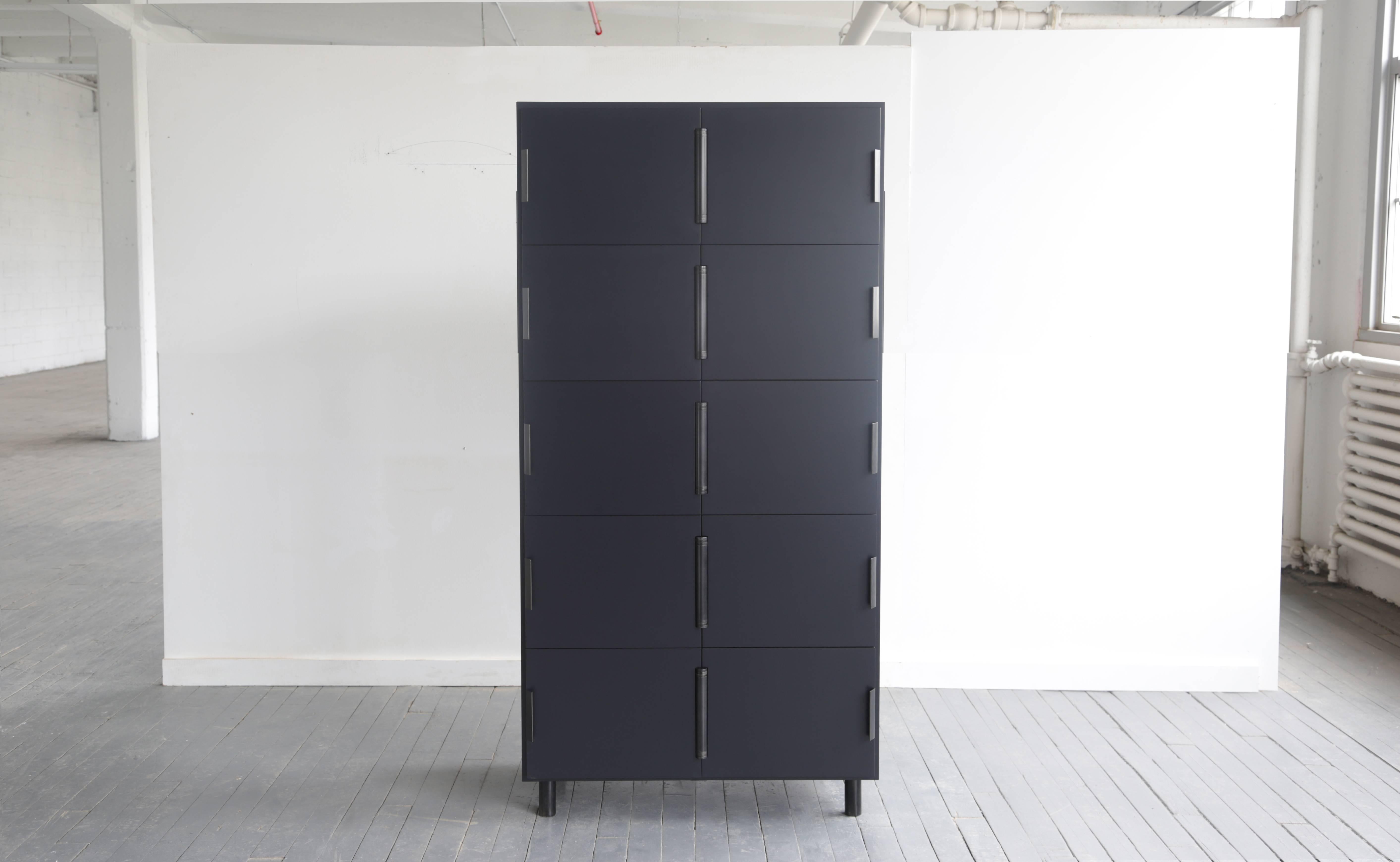 Nocturne is a multi-use storage cabinet with an austere beauty. Its center-hung doors swing inward on a shared hinge. The case is matte lacquered wood with blackened steel hardware. 

Available finishes: 
Black blue and blackened steel