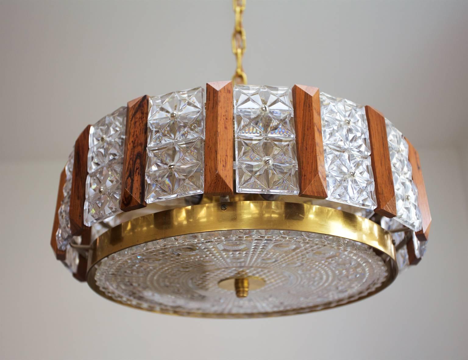 A very beautiful and elegant chandelier. Brass, teak construction with pressed glasses/crystal elements, six E14 sockets. Can be fitted with socket converters to US standards.

By Carl Fagerlund for Orrefors, Sweden, 1960s.