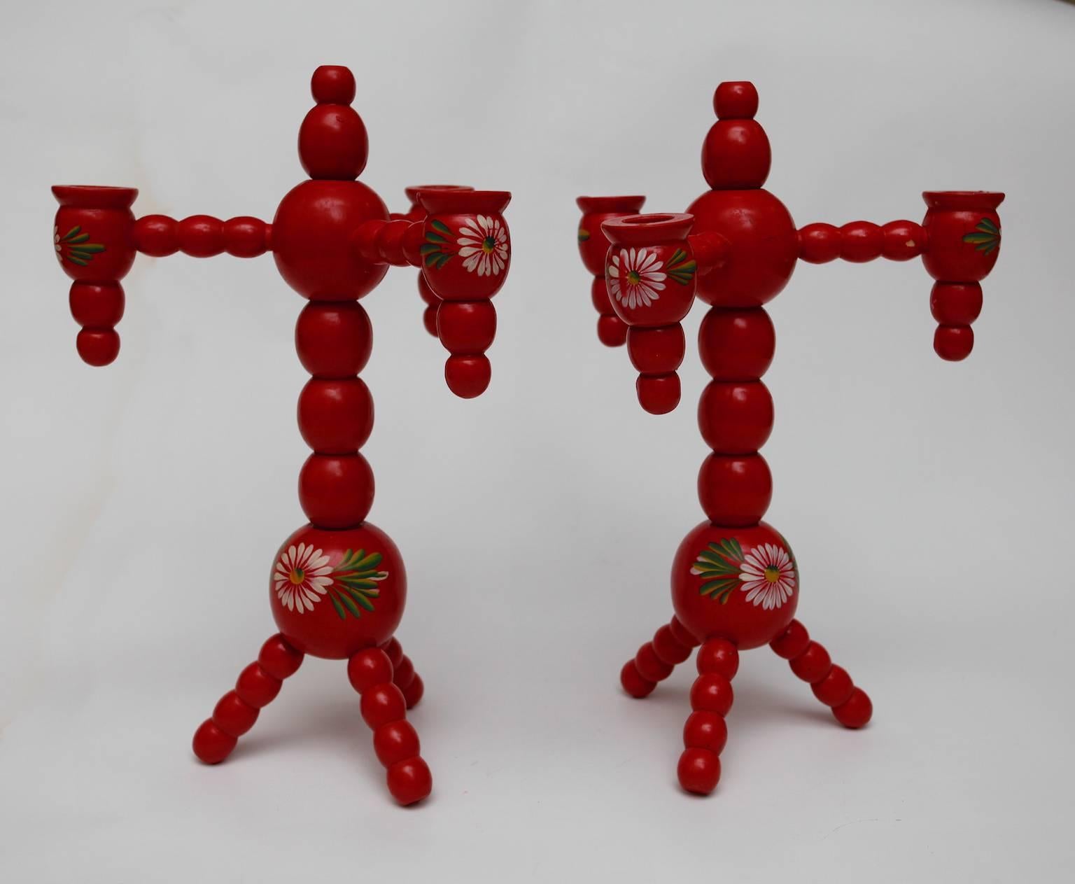 Traditional wooden, red Swedish christmas candelabras for three candles on Tripod Foot. Turned and hand-painted in traditional "Kurbits" style. 
At this time of the year these candelabras are decorating many Swedish homes tighter with