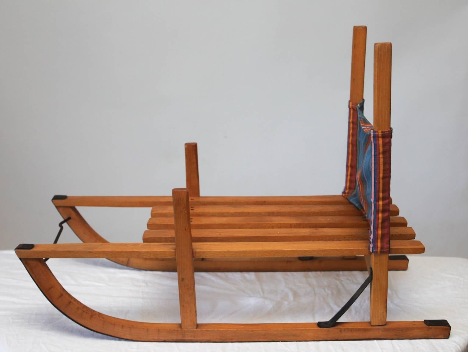 This is a very fine high quality and traditional childrens wooden Sledge from Sweden. The fabric is removable.
Probably made somewhere between 1910-1950s, Steel Reinforced skids and struts. It is unique since most today are made of plastic and