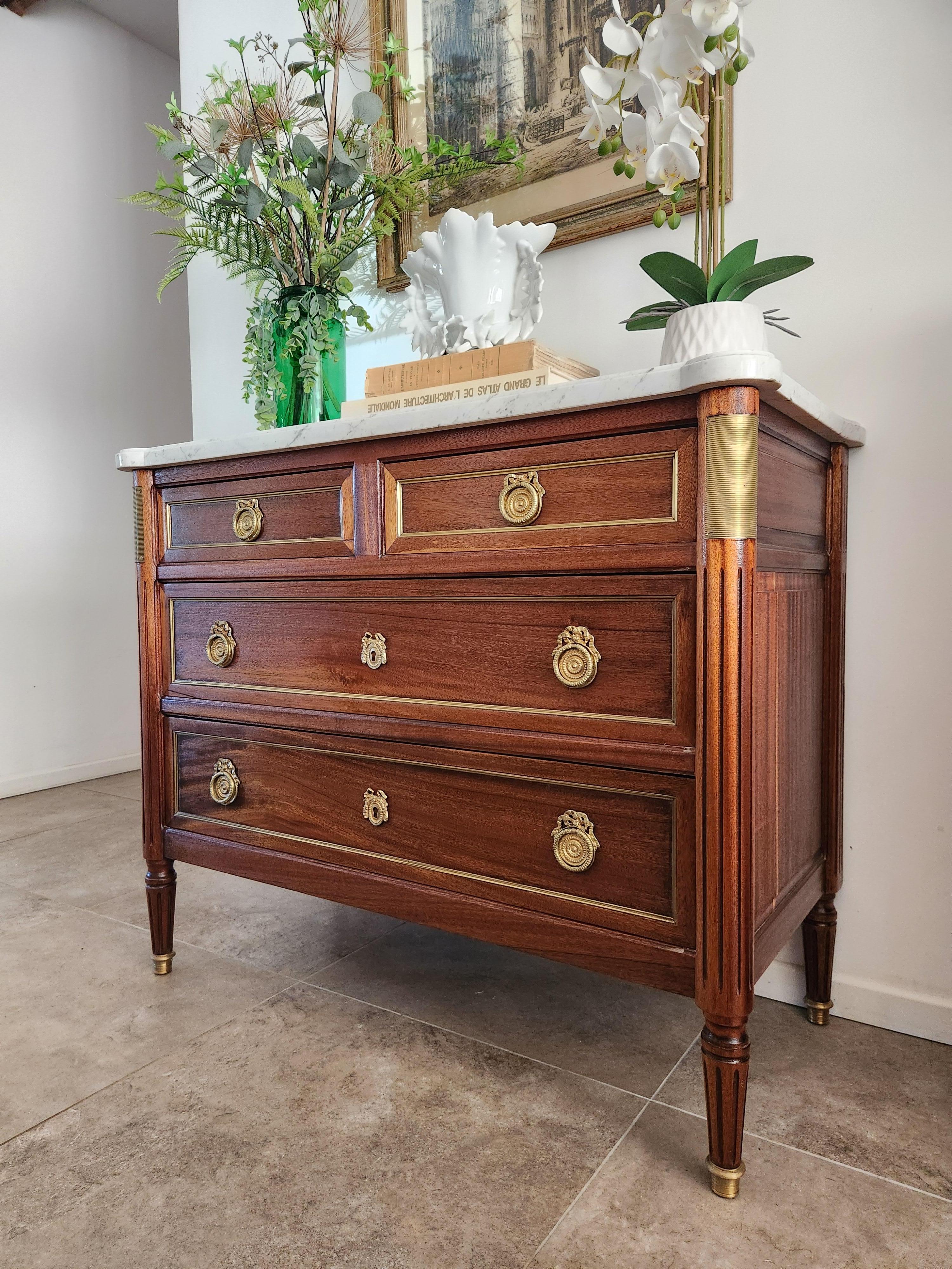 Antique French, Louis XVI style chest of drawers topped with a white Carrara marble, fluted legs finished with golden bronze clogs. 
Four dovetailed drawers with bronze and brass details. The furniture is signed.

 
The photos and video accurately