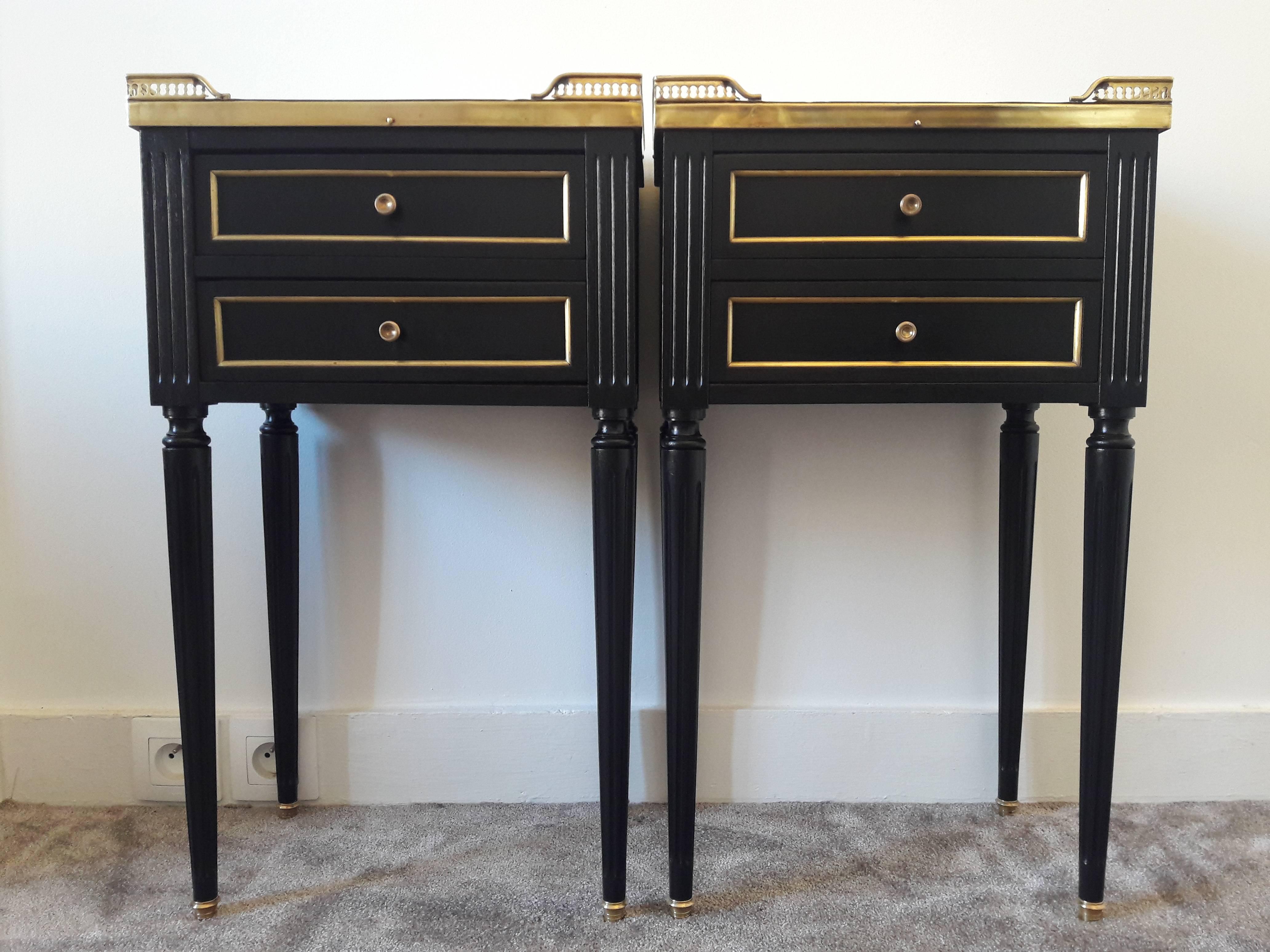 Antique French Louis XVI style pair of nightstands topped with a white Carrara marble, fluted legs finished with golden bronze clogs. Two dovetailed small drawers with brass details.