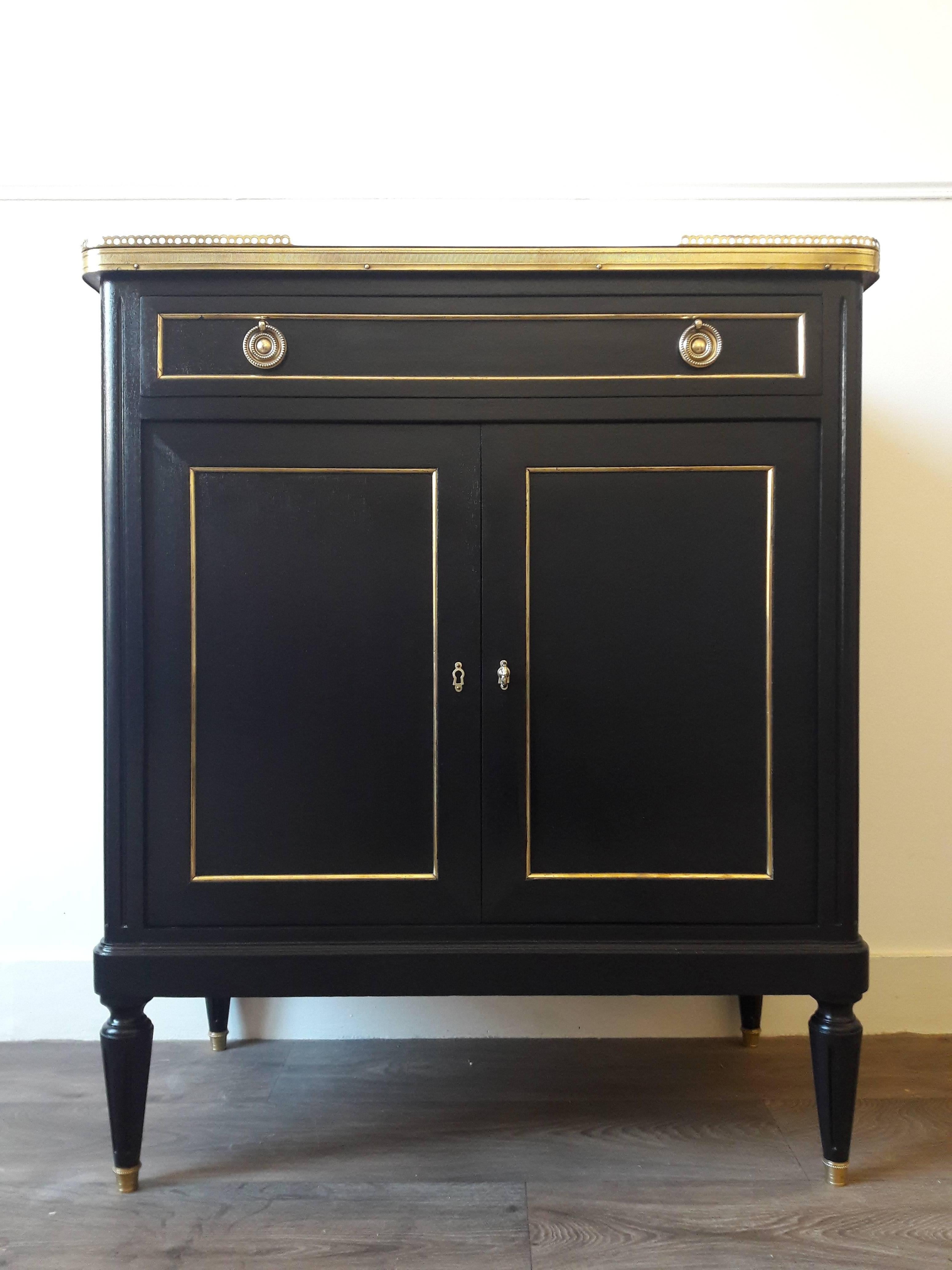 Antique French Louis XVI style bar buffet and topped with a white Carrara marble, fluted legs finished with golden bronze clogs.
One drawer, two doors and the key.
Perfect to create a small whiskey bar in the living room.