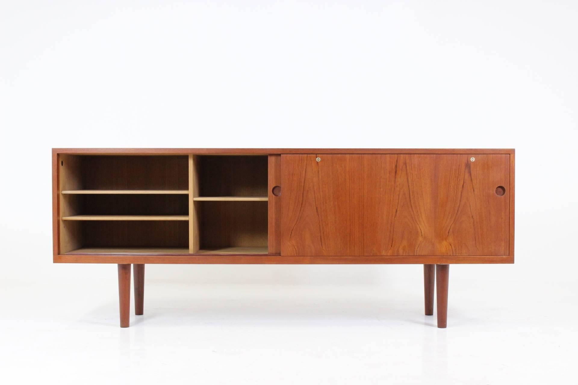 A teak sideboard, model 26, designed by Hans J. Wegner for RY Mobler in Denmark, circa 1965. This simple sideboard has two sliding doors with shelves and four drawers inside. The item was carefully restored.