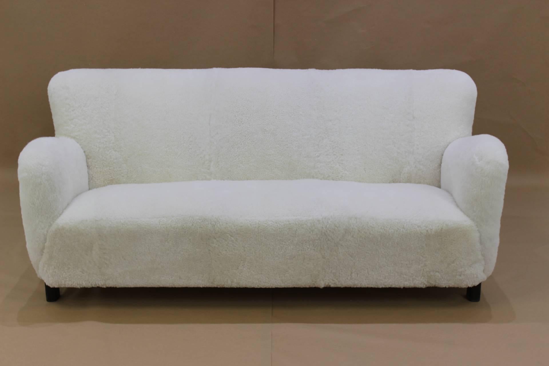 Beautiful Danish "Fritz Hansen" sofa in sheepskin upholstery suitable for open spaces.
The sheepskin were carefully selected and their weren't chemically treated (to be more white). The wooden legs are made of solid mahogany.