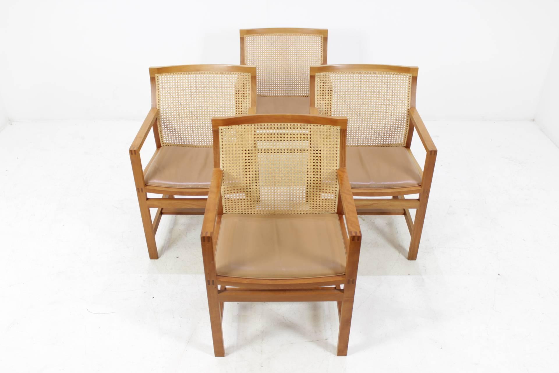 The chairs (model 7512) are in good original condition and ready to be used. Material: Stained oak, leather, cane.