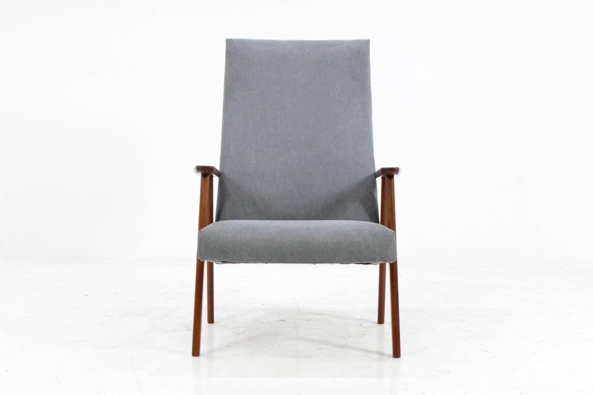 The chair features wooden teak frame and new fabric upholstery. Item was carefully refurbished.