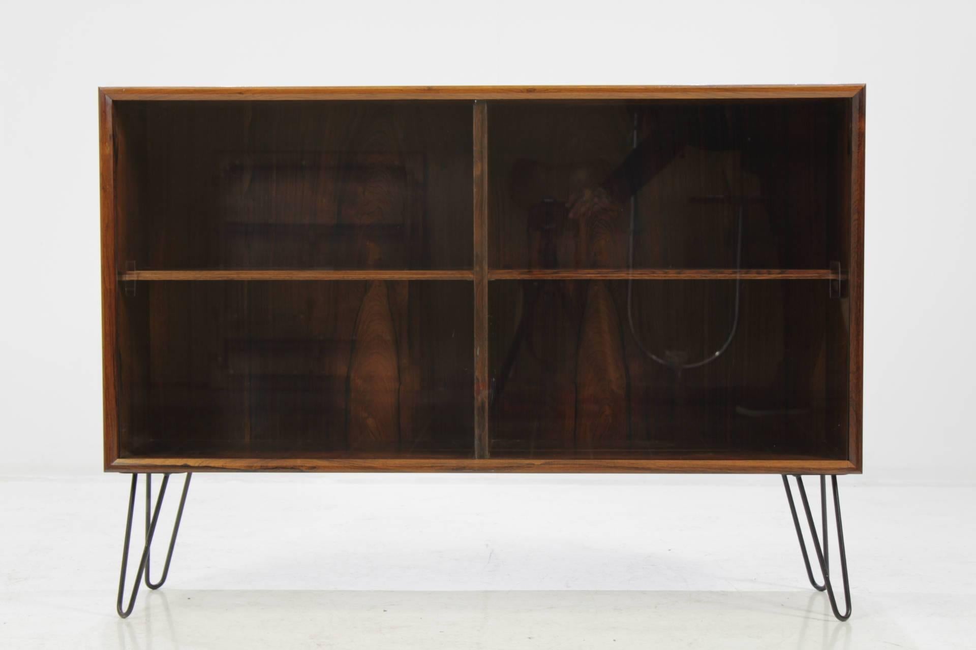 This cabinet features two sliding doors made of glass and two inner adjustable shelves. The item was carefully restored. The hairpin iron legs were added afterwards.