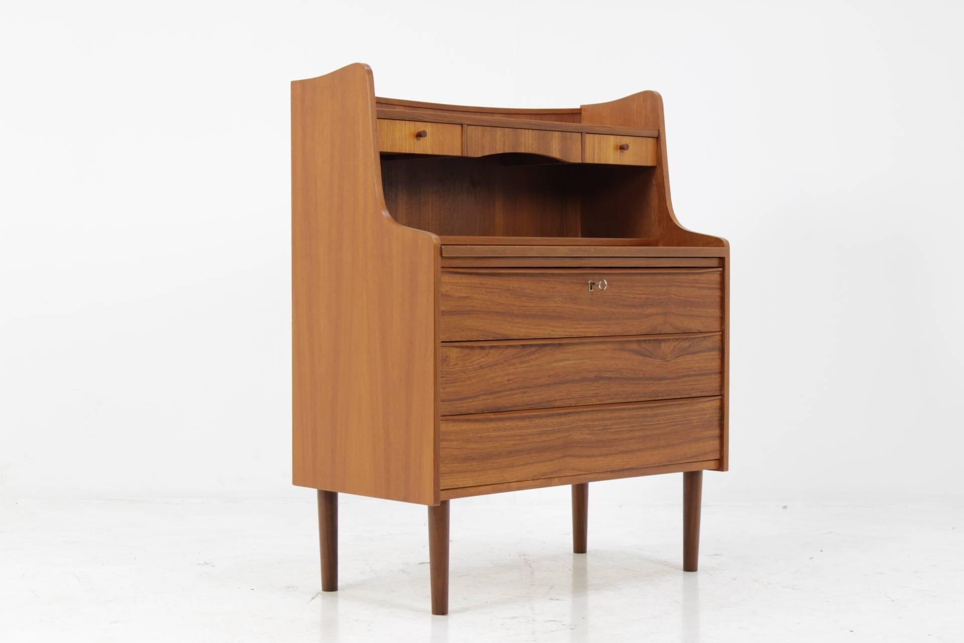 This Danish teak writing cabinet features three large drawers and two small ones . The extendable writing area desk can be extended up to 61cm. This item was carefully restored.