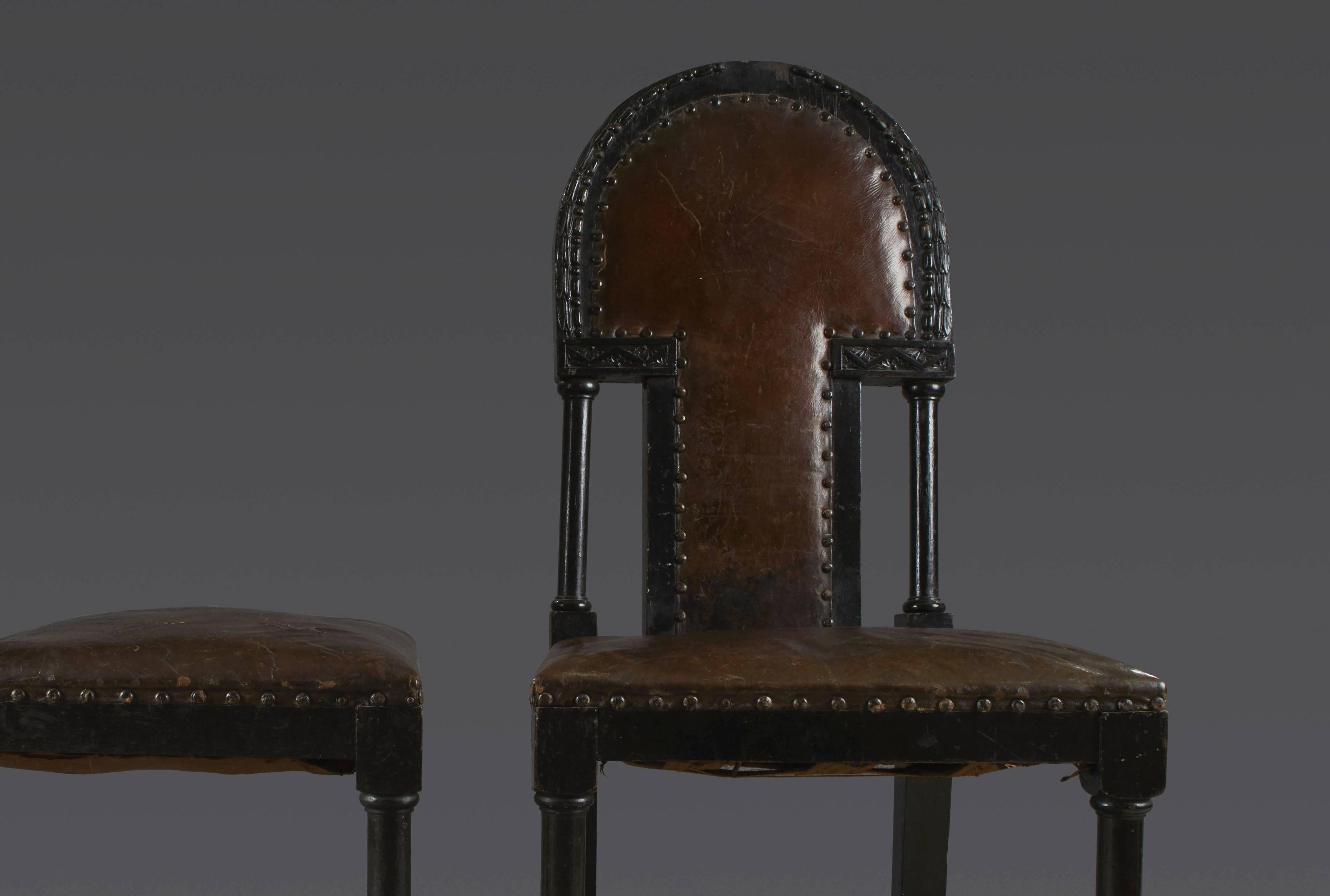 Set of six chairs in darken wood and studded brown leather - arched back with small columns decorated with bay leaves friezes, pearls and two small lintels with foliage motif, turned legs joined up with brace, Vienna 1920 Post Secession. Dimension: