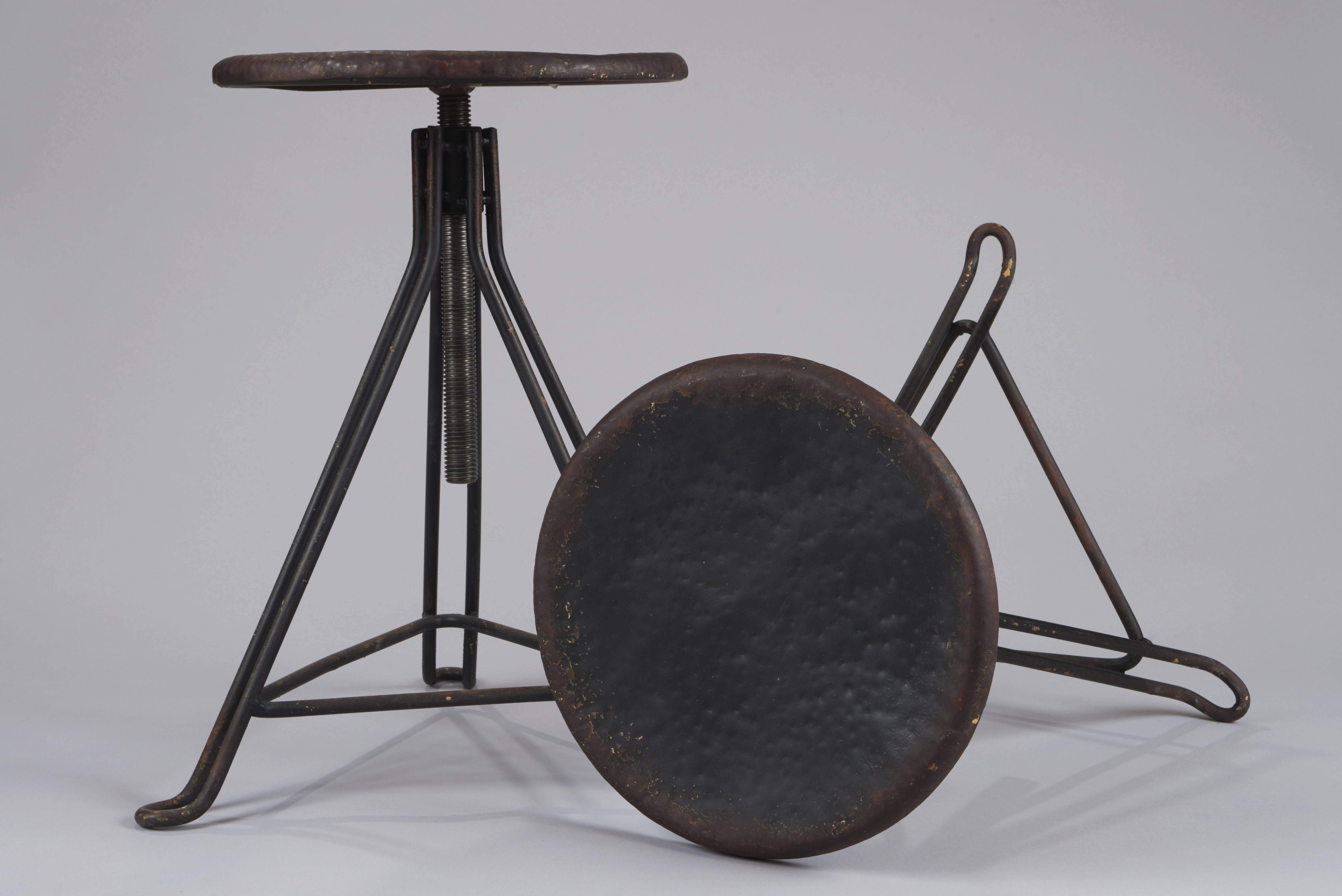 Pair of small circular workshop stools - tripod - black patina - in screw, France, 20th century. Dimensions: diameter 30cm, H min 45 cm, H max 70.