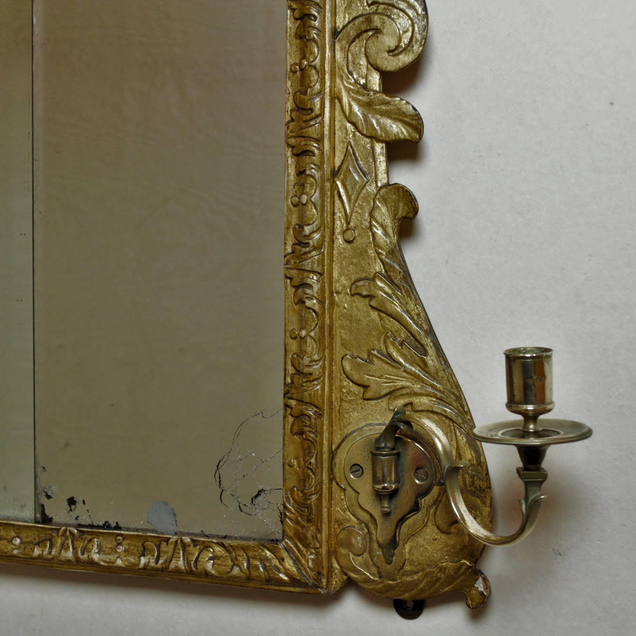 A good mid-18th century triple-plate George III carved giltwood framed overmantel mirror with acanthus leaf borders and scrolled sides.
(The left hand glass panel has been replaced with an matching piece of 18th century glass which has been