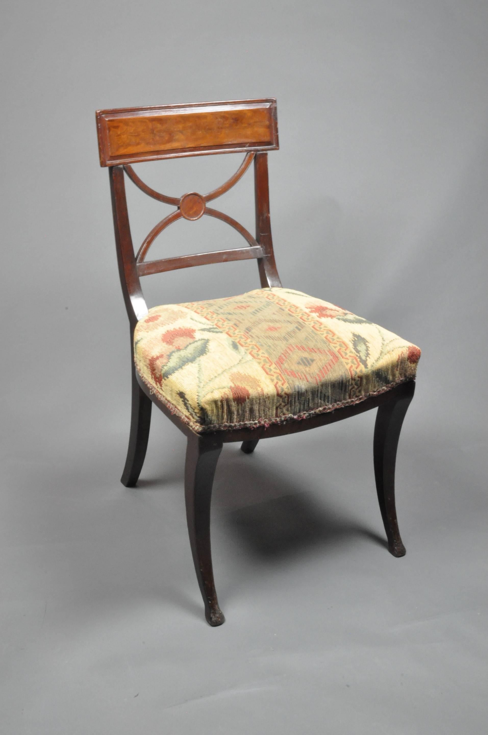 A good set of eight high Regency mahogany dining chairs in the style of 'Thomas Hope'. The curved rectangular backrests, above moulded 'X' shaped splats and upholstered seats, standing on 'sabre' legs, circa 1815.
 