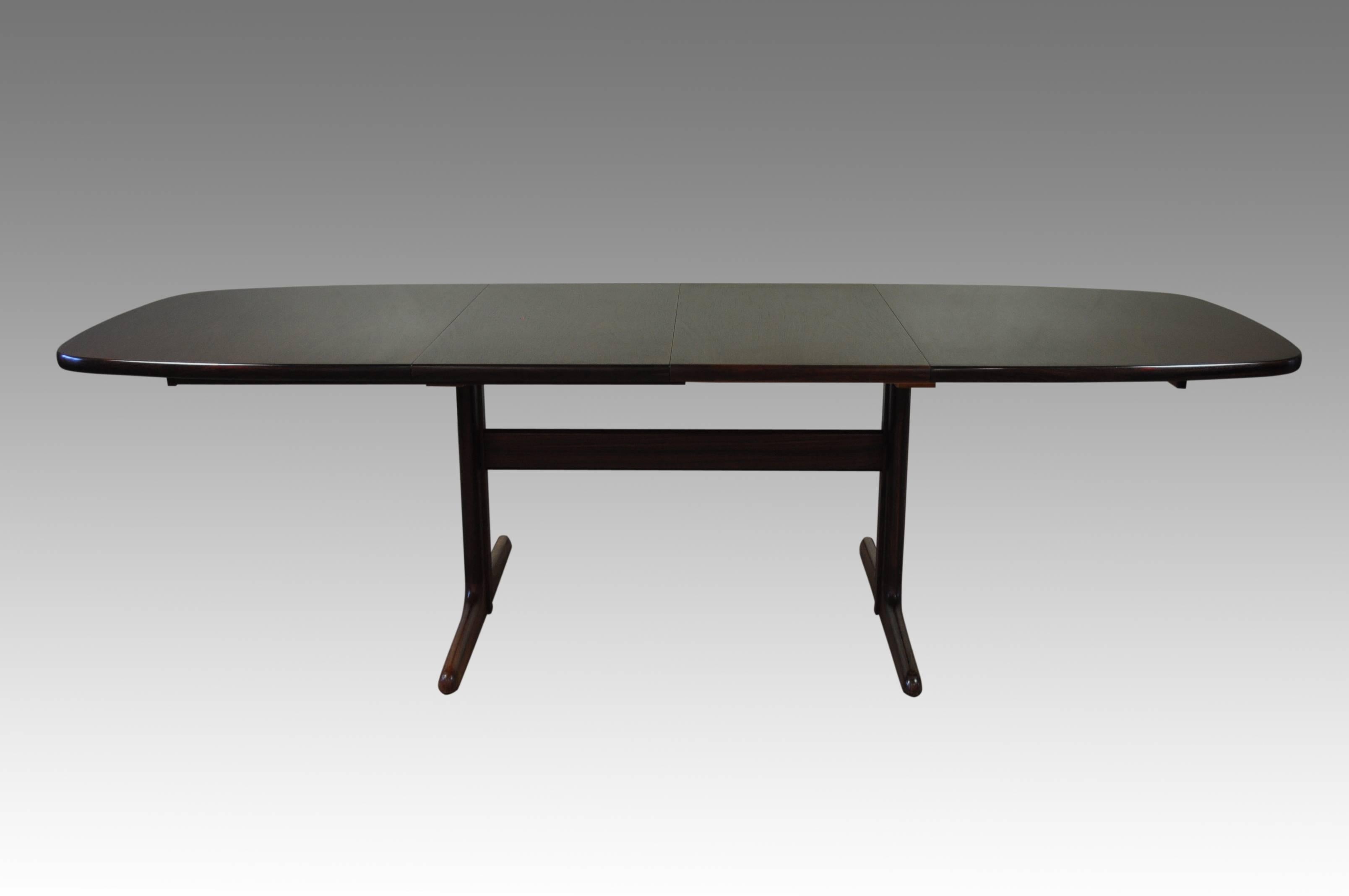 A fine quality 1970s rosewood extending dining table with two removable leaves and standing on stylish trestle supports. Leaves are independently removable allowing for lengths of 165 cms, 212 cms or 264 cms, seating up to ten. In-used leaves can be