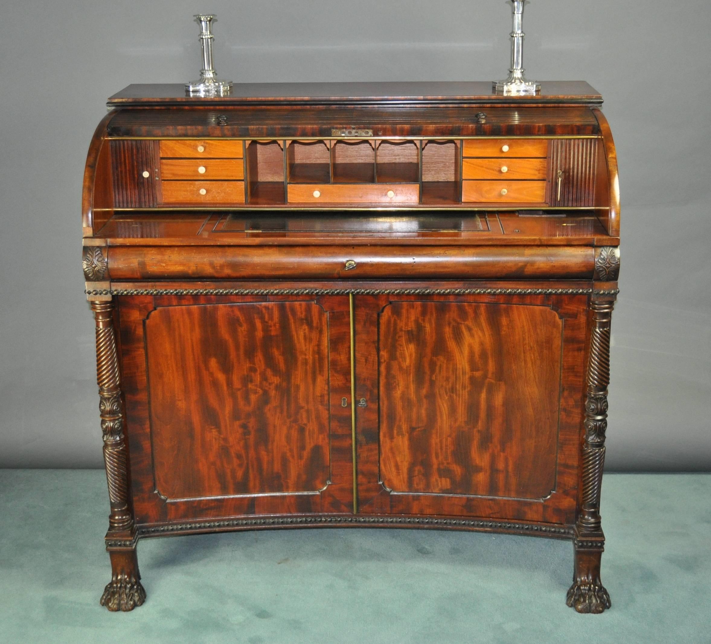 Exceptional quality Regency period, figured mahogany tambour top desk. The tambour shutter opening to reveal a leather lined, ratcheted writing surface and sunken tray for pens and ink, and a second, horizontally opening pair of tambour shutters,