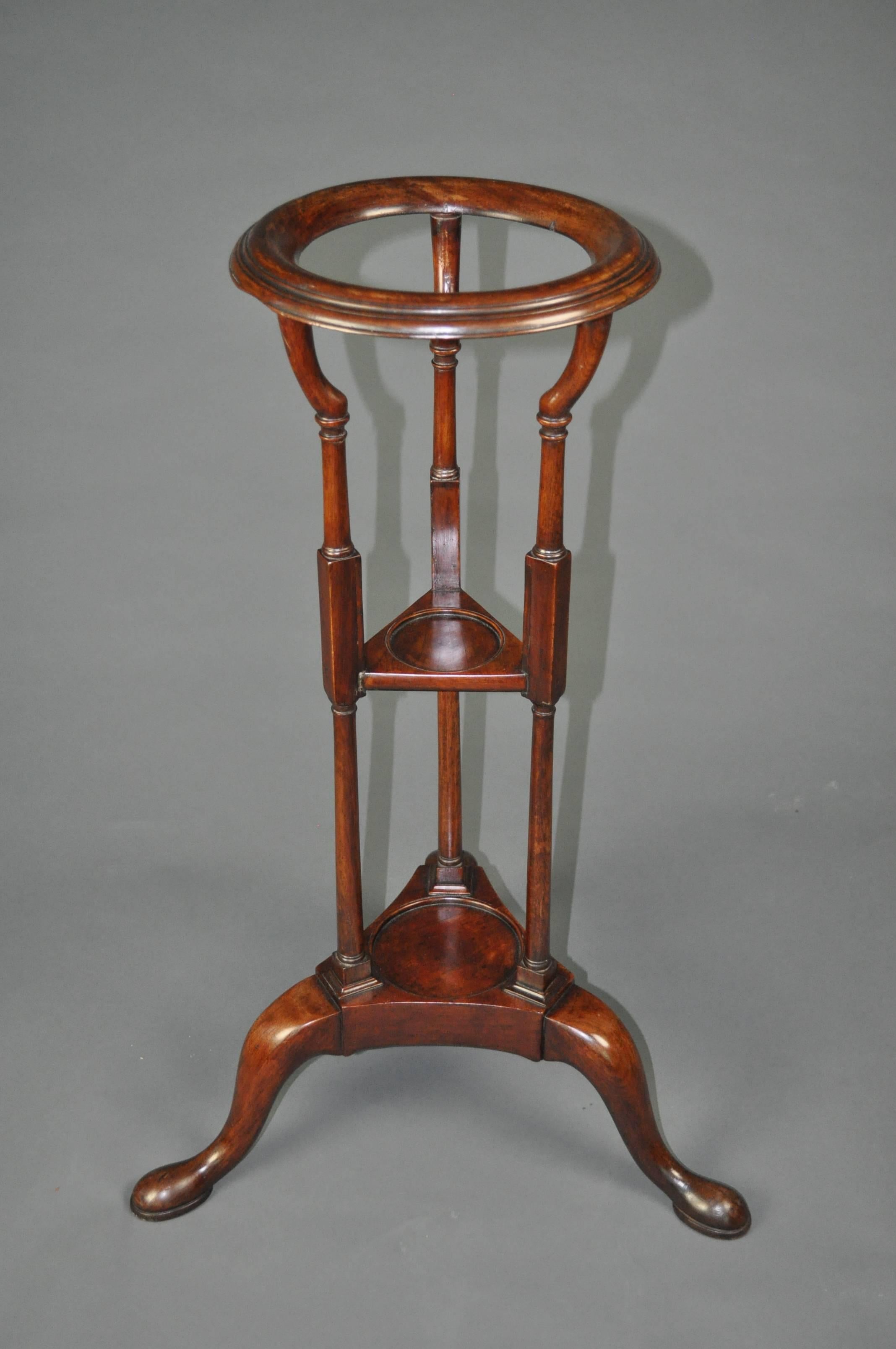 An 18th century mahogany basin Stand, with circular top supported on three slender turned columns with shelves below for a cup and a jug, and raised on an attractive tripod base with cabriole legs and pad feet. Measures: 11 inches diameter at