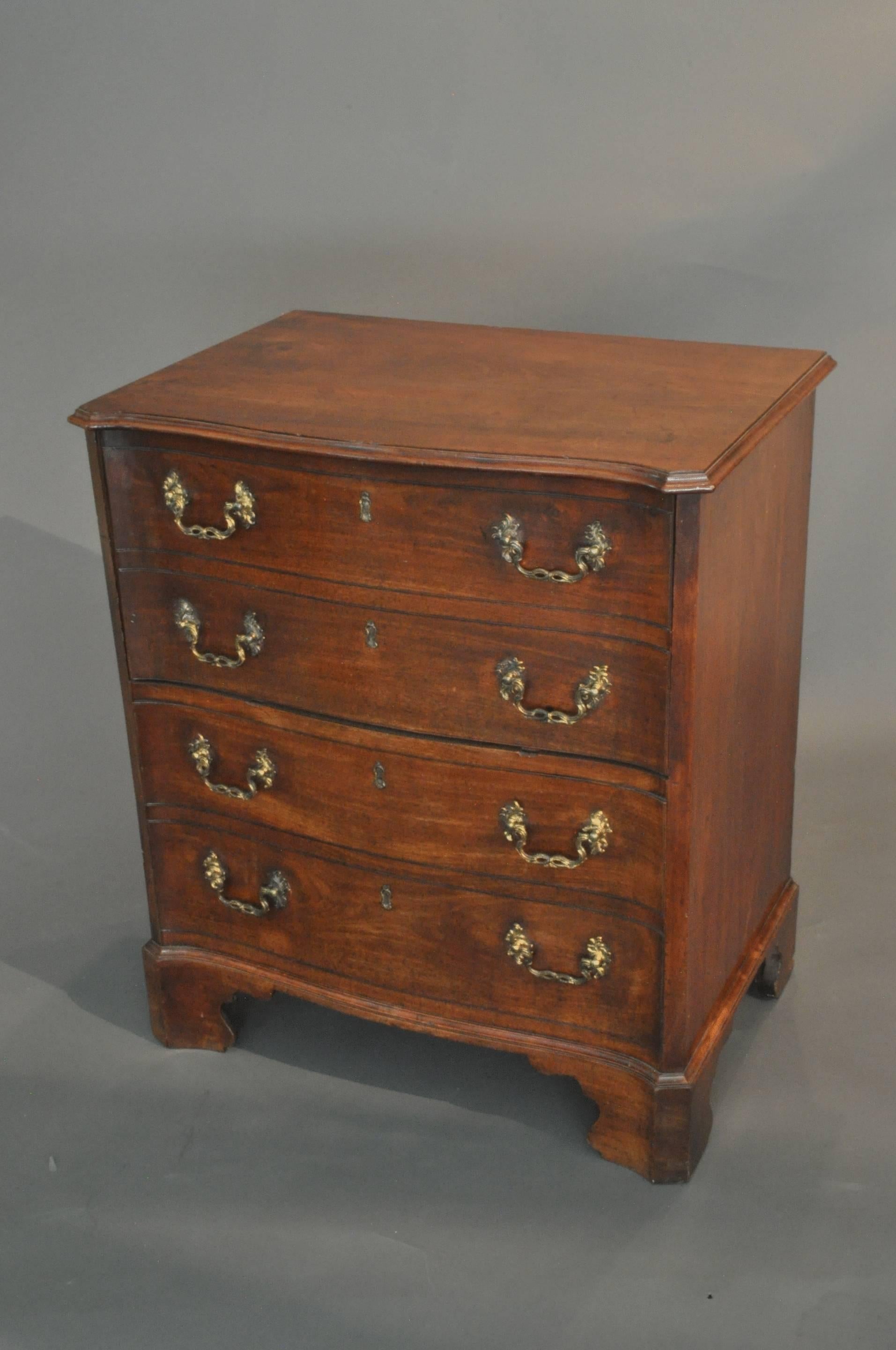 A fine quality and rare serpentine fronted bedside commode in the form of a small chest of drawers. The top with thumb nail moulded edge above four dummy drawers each fitted with the original fire gilded brass rococo style handles and standing on